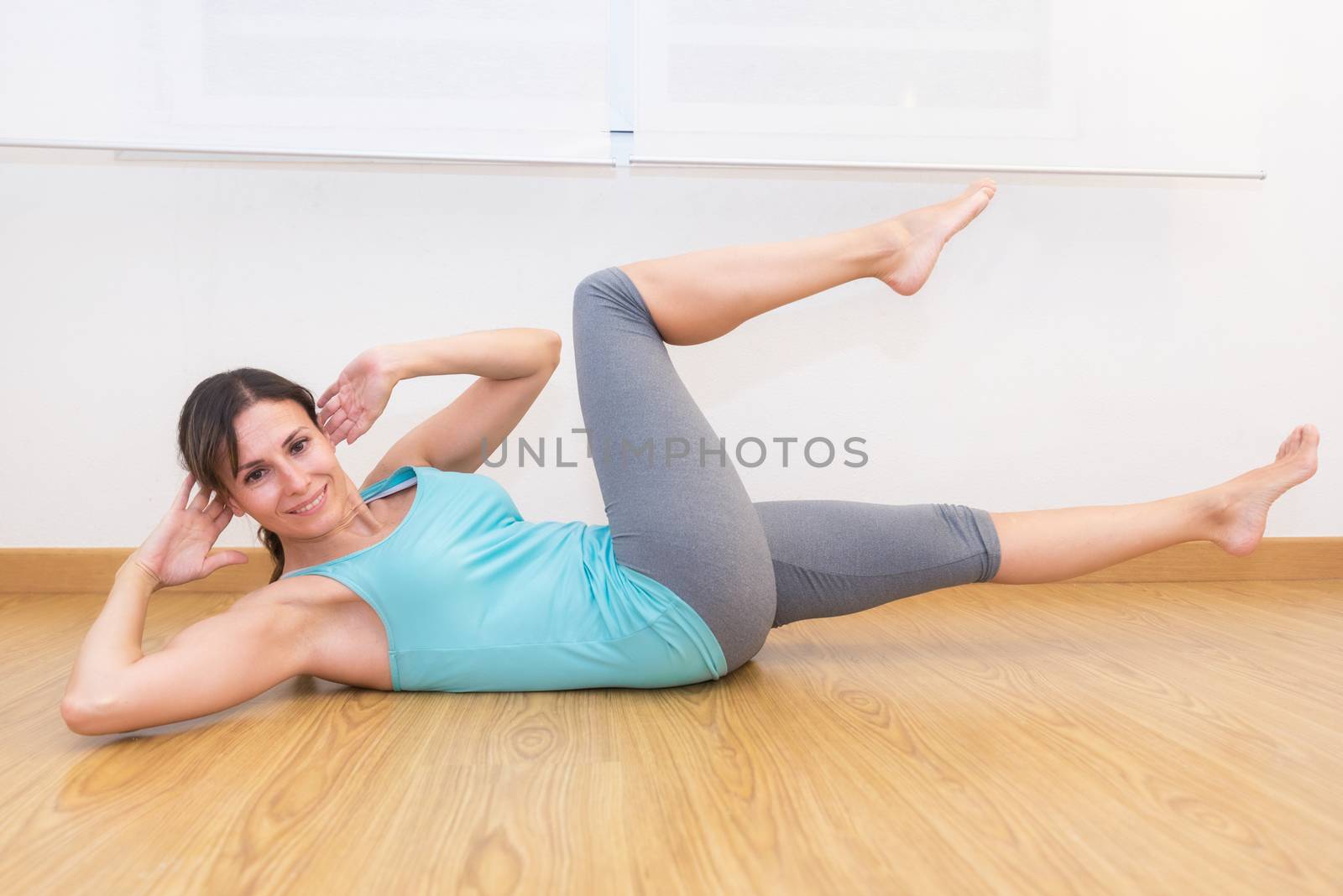 Attractive fit woman wearing sportswear working out abs at home