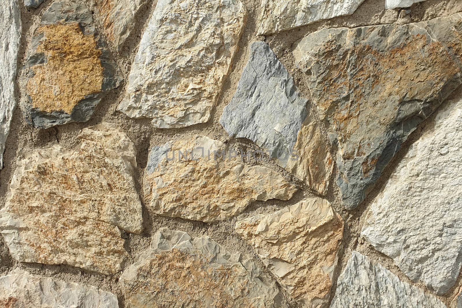 A stone wall of raw stone. Texture of stone.