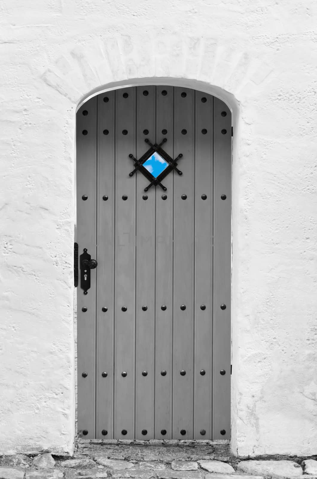 Wooden door in the old white wall