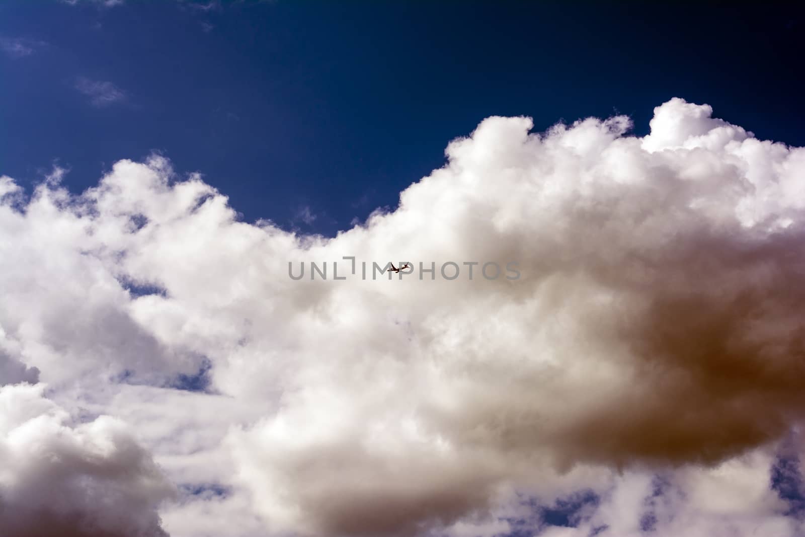 Airplane flying in the sky surround by clouds.