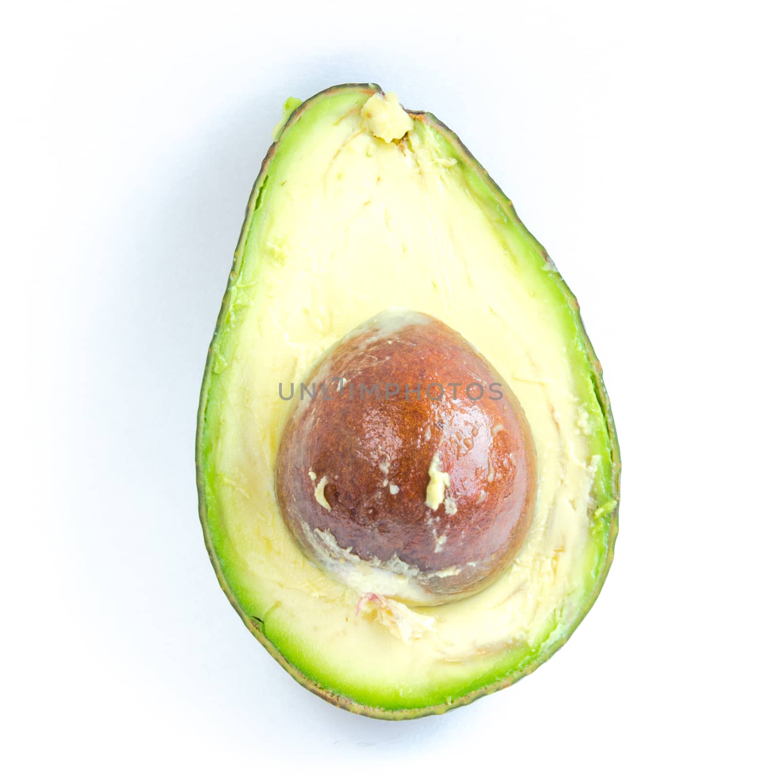 Close-up single half cut of avocado isolated on white background. Ripe organic Persea Americana, healthy fat fruit