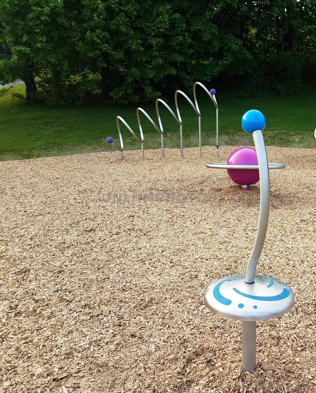 play structure at playground with metal spinner and wood chips