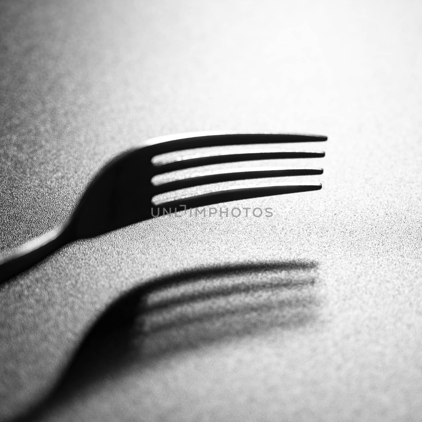 the shadow of a fork on a black surface