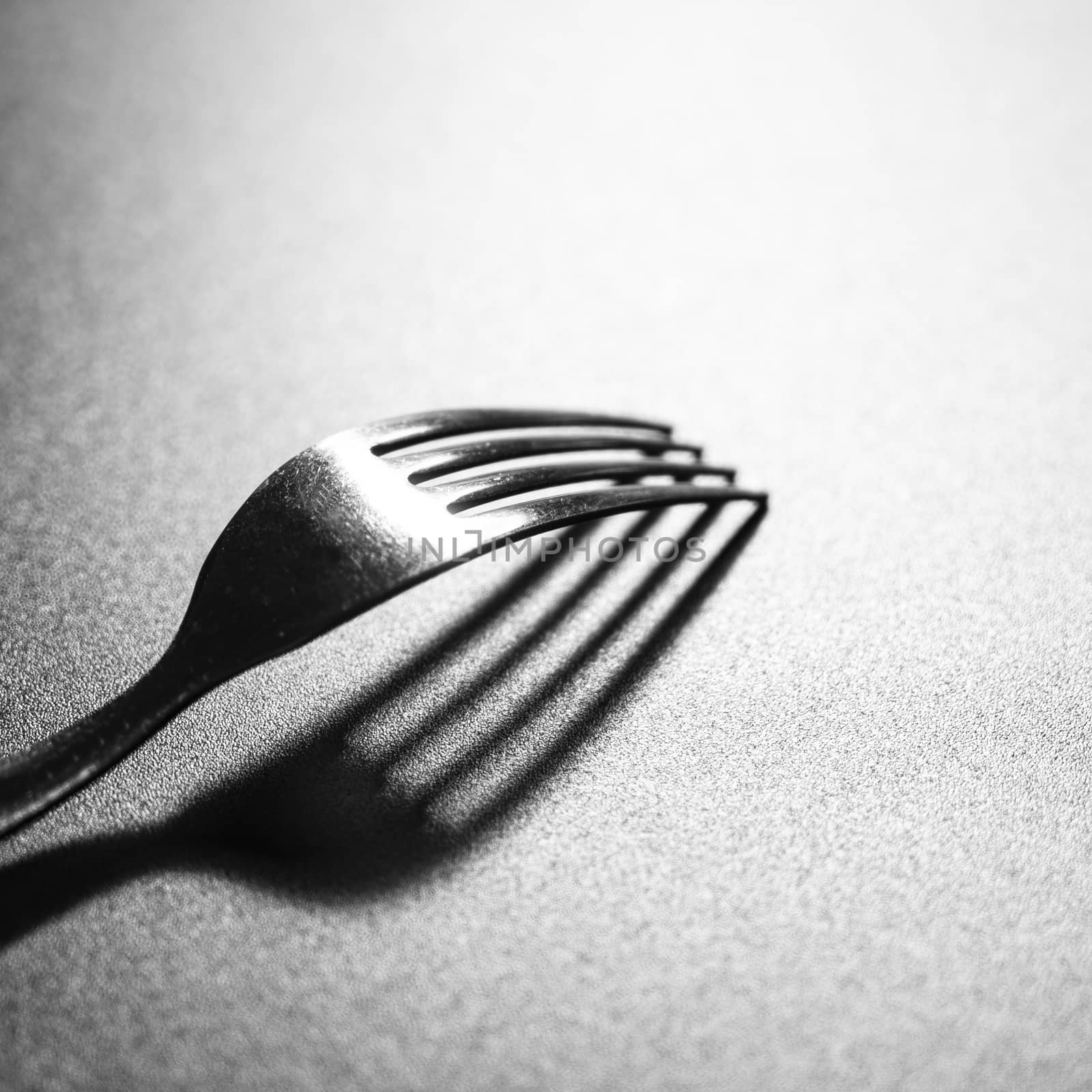 the shadow of a fork on a black surface