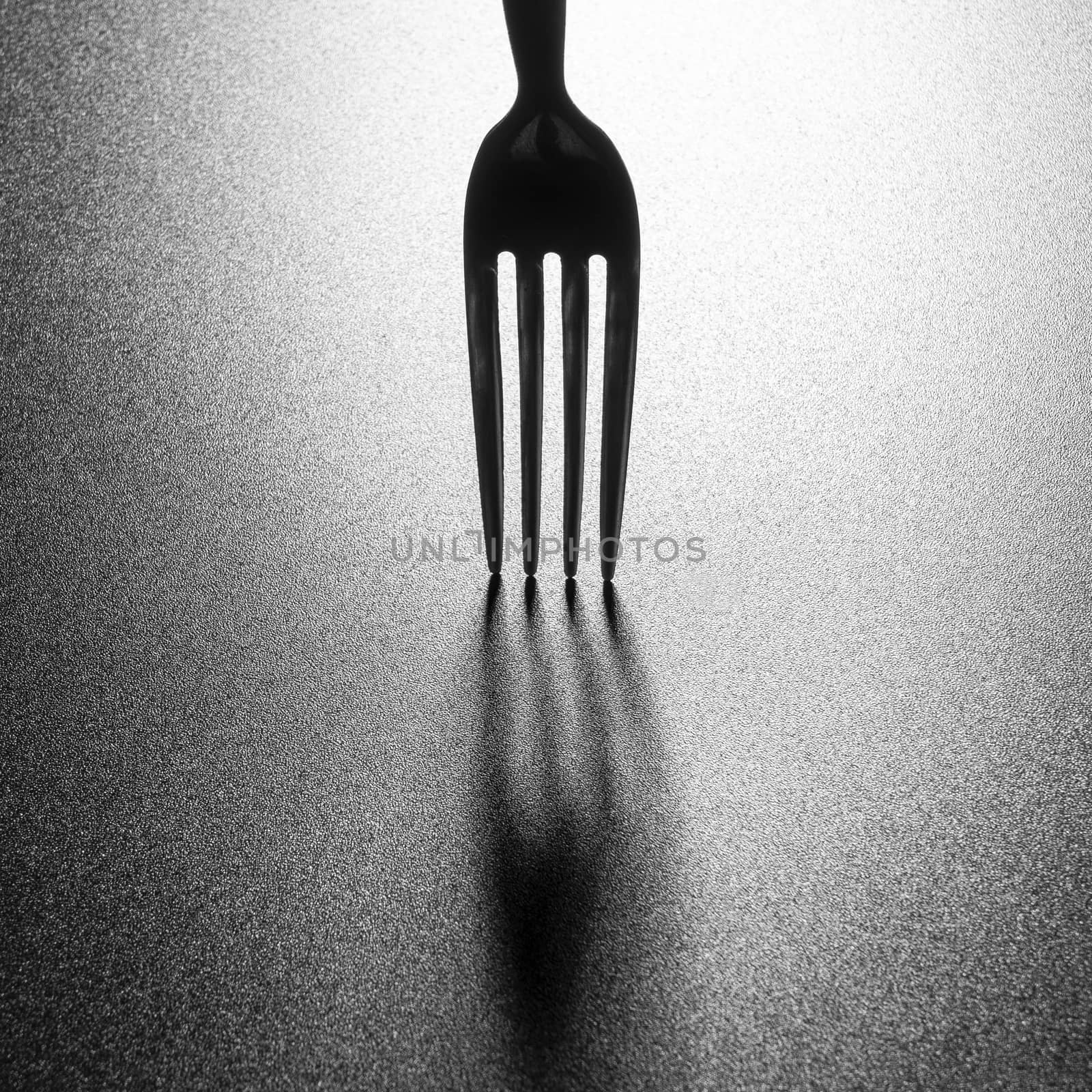 the shadow of a fork on a black surface