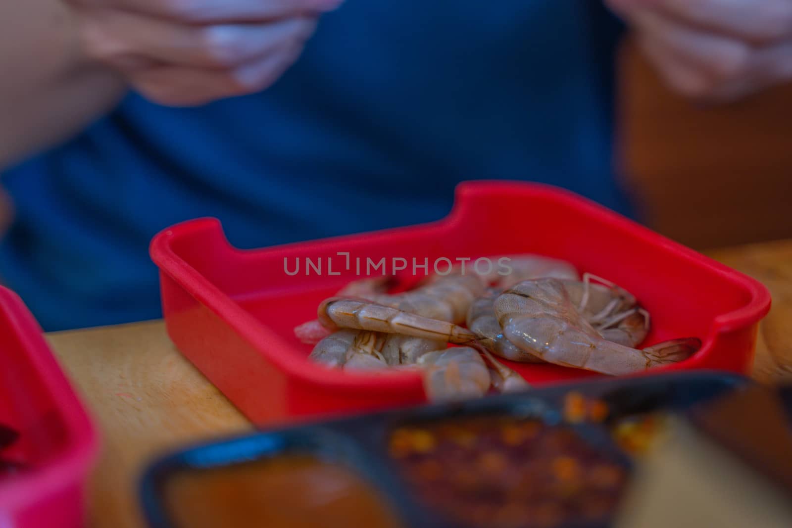 The Raw whole fresh uncooked prawns shrimps on stone red plate