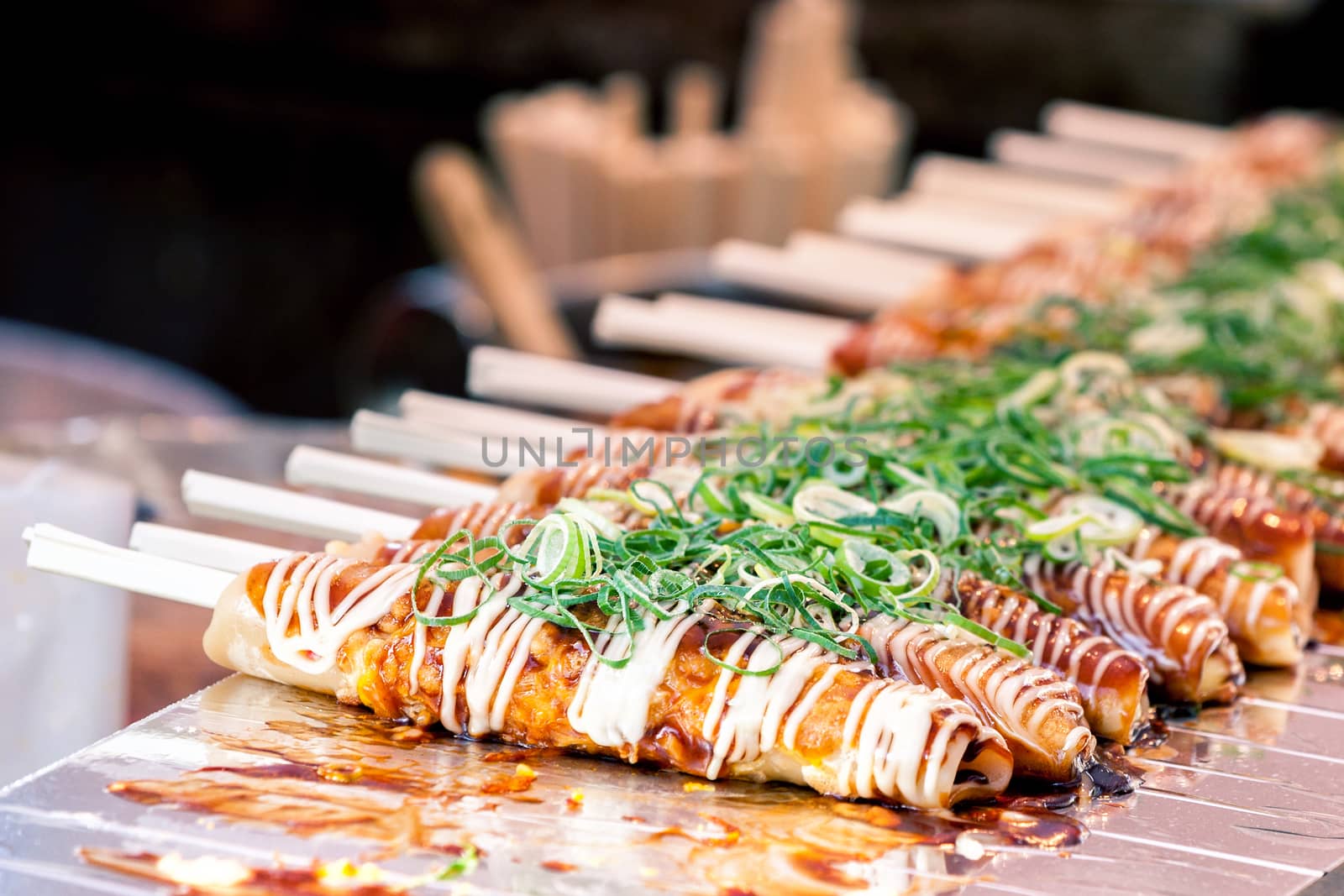 Okonomiyaki on wooden sticks with soy sauce and mayonaise topped with green onion at Nishiki market, Kyoto by zhu_zhu