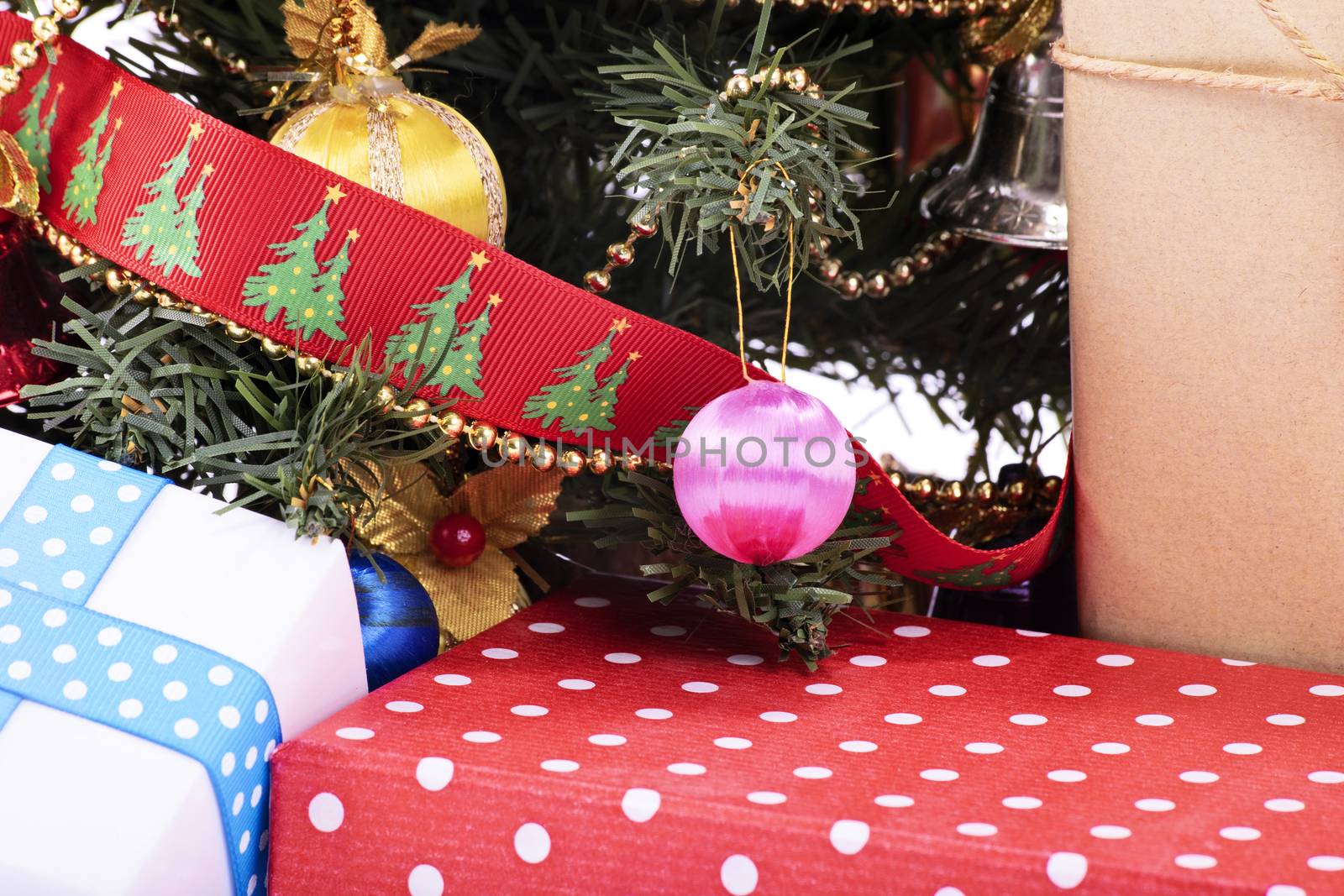A close up shot of Christmas tree with decorations, ornaments and presents.