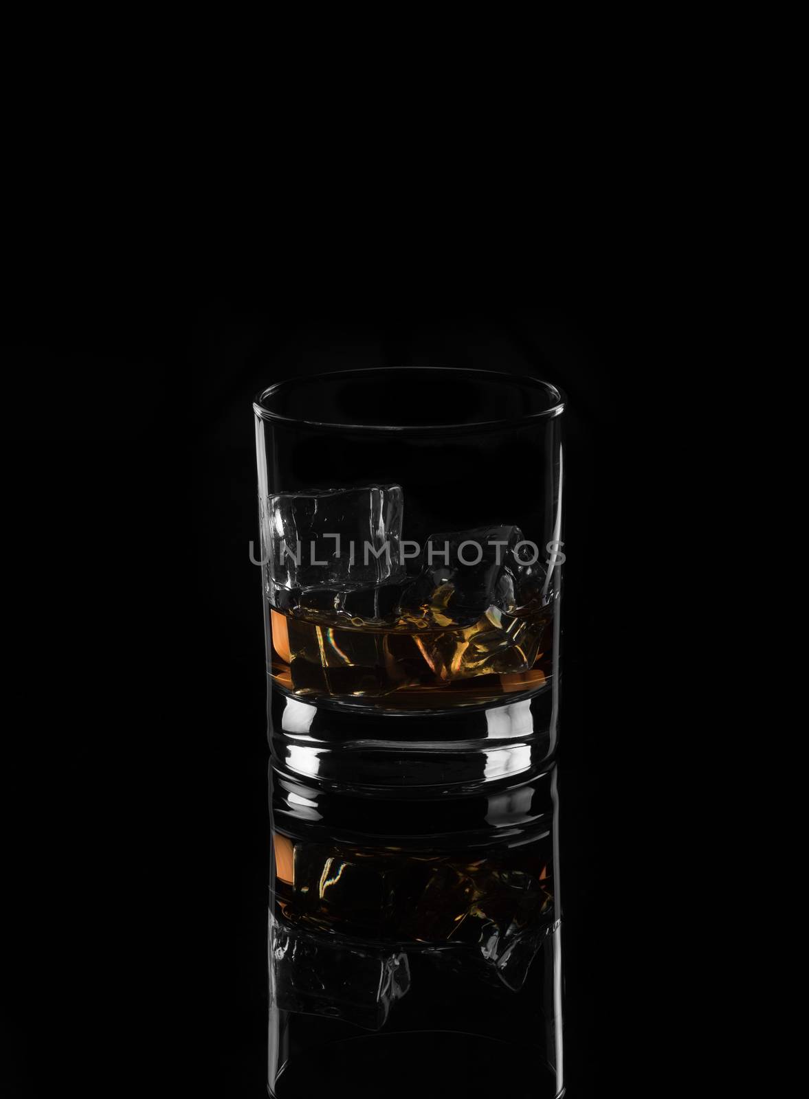 Alcohol.Wwhiskey with ice on a black background