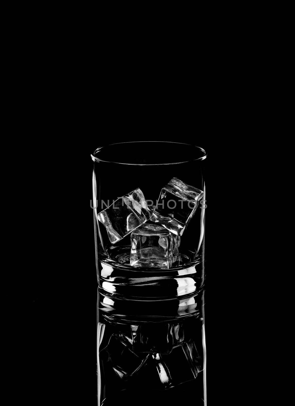 Vodka lime or gin tonic with ice in rocks glass on black background including clipping path