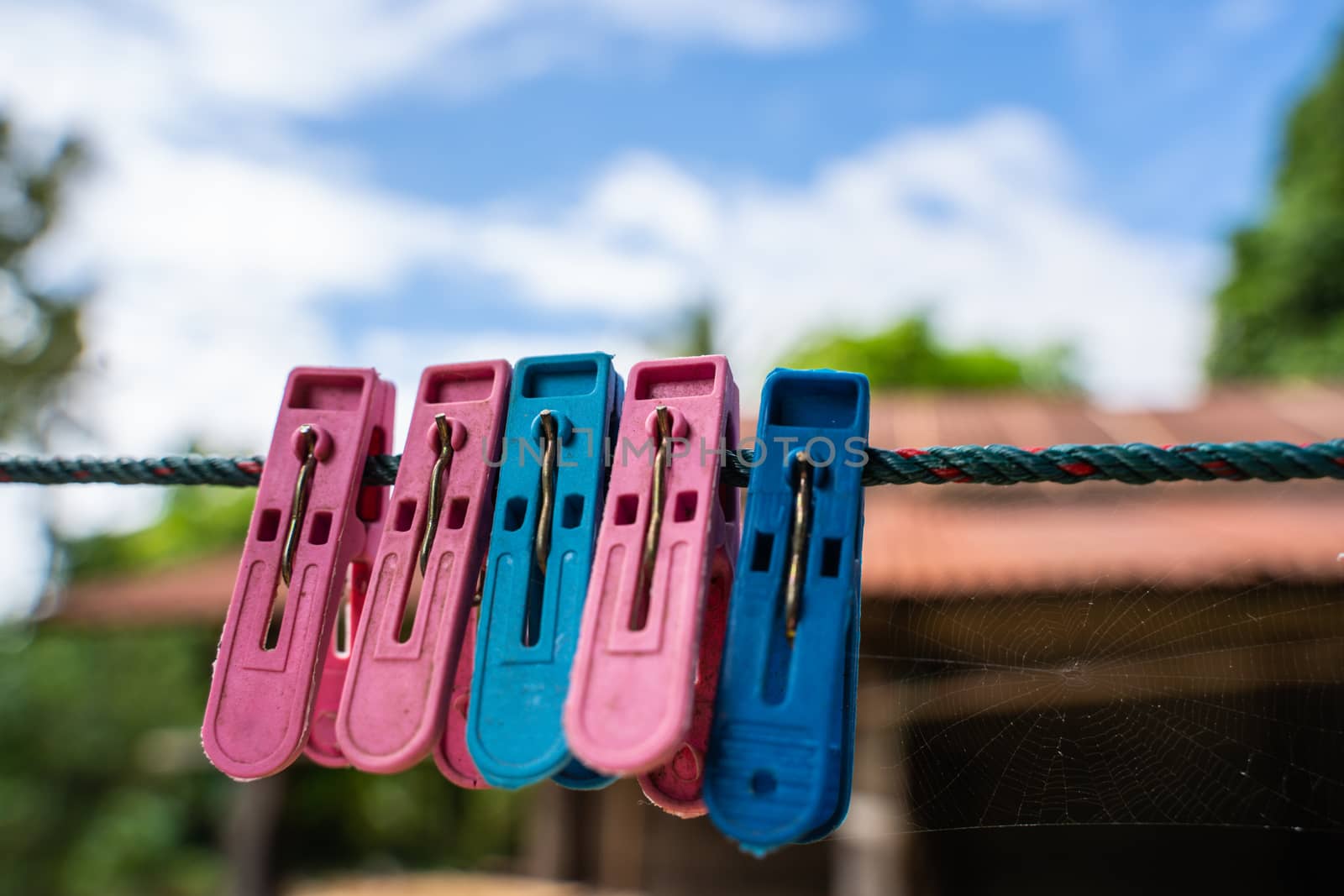The colorful plastic clothespin on sky background