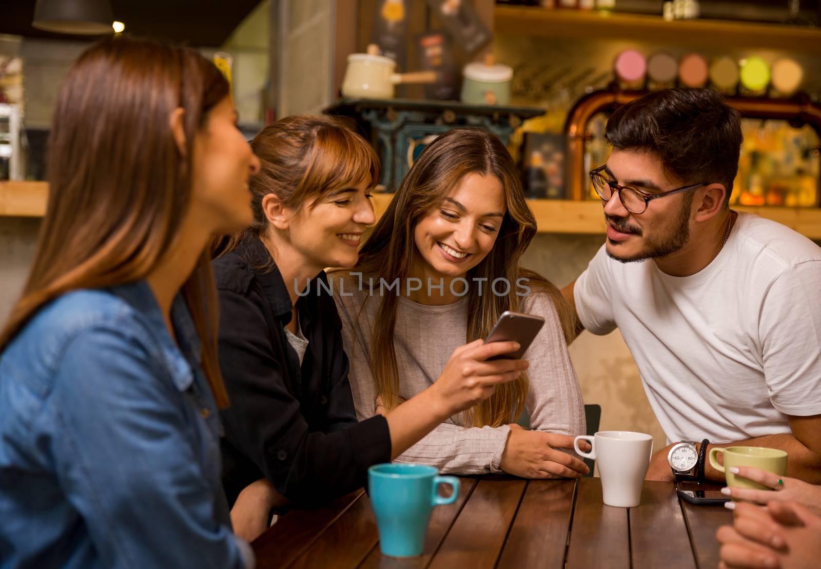 Friends hangout at the cafe and watching something on the phone