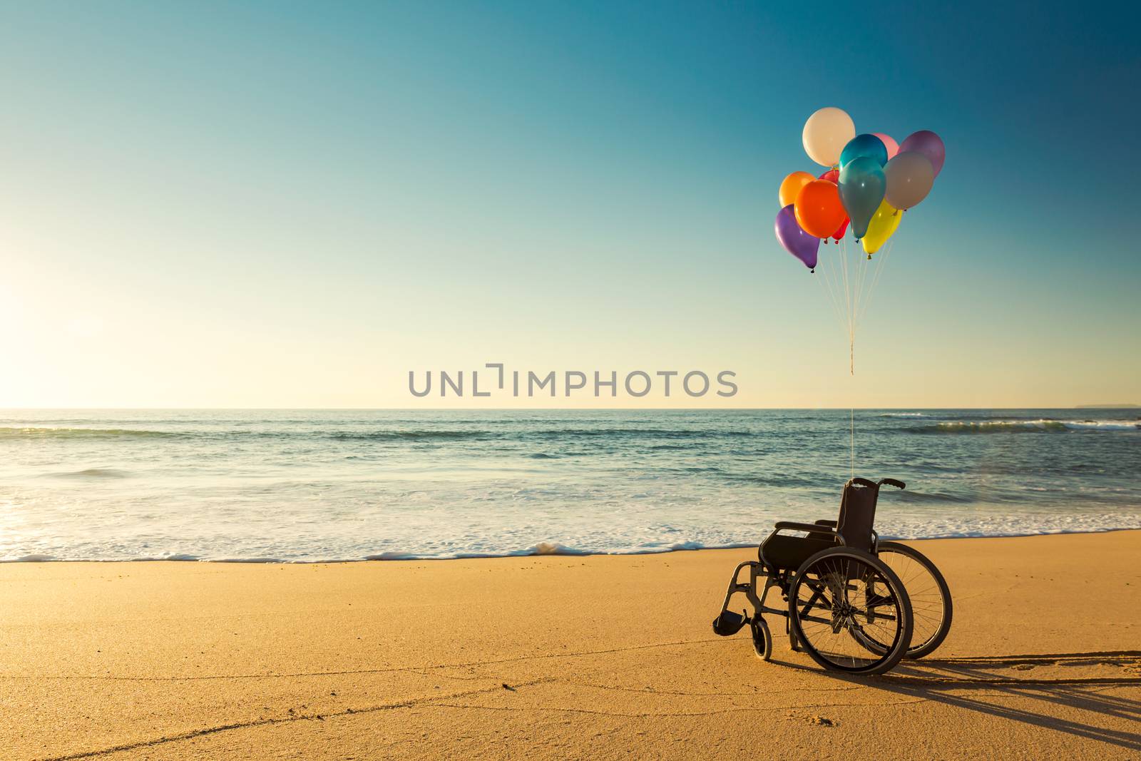 Wellchair on a beach with colored  ballons 