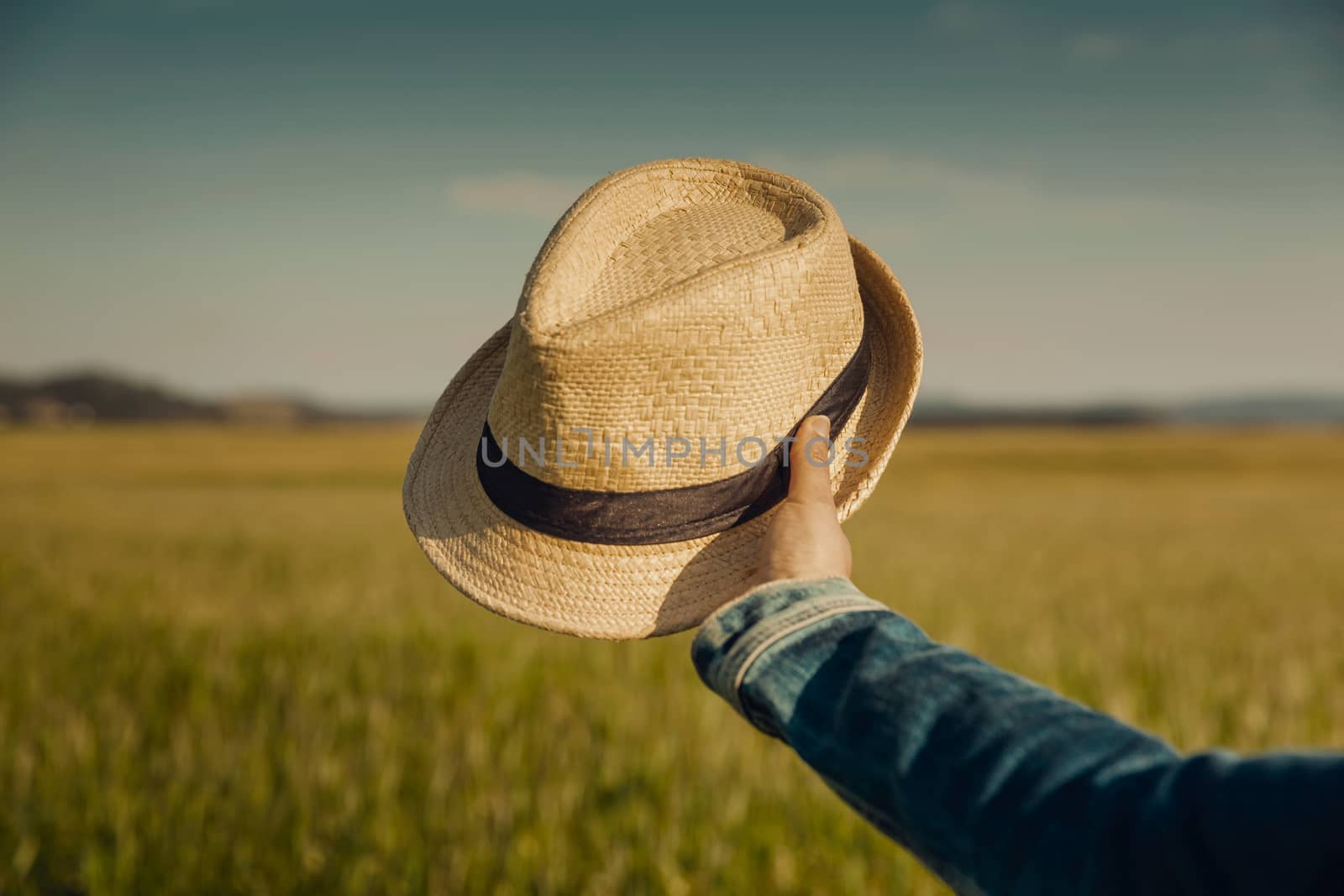 Female hand holding  a straw hat 