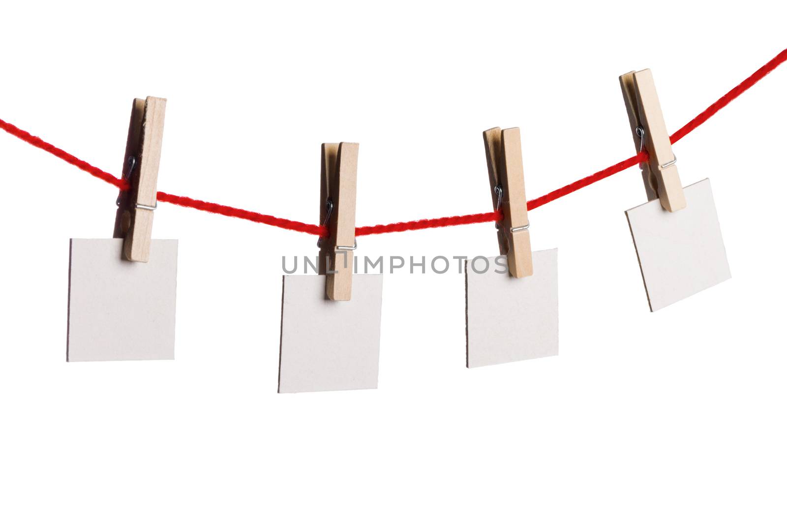 Four old blank notes hanging on the rope with wooden clothespins isolated on white background
