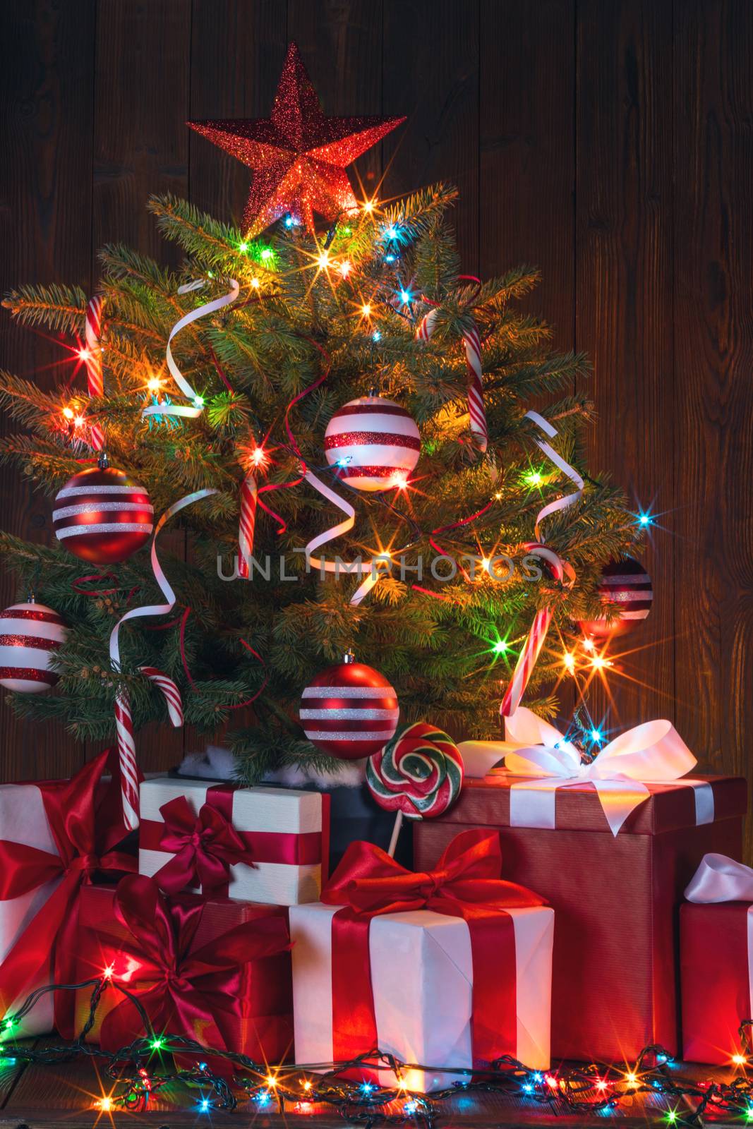 Beautiful glowing decorated Christmas Tree and many gifts