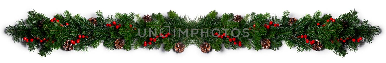 Christmas Border frame of tree branches red berries and pine cones on white background with copy space isolated