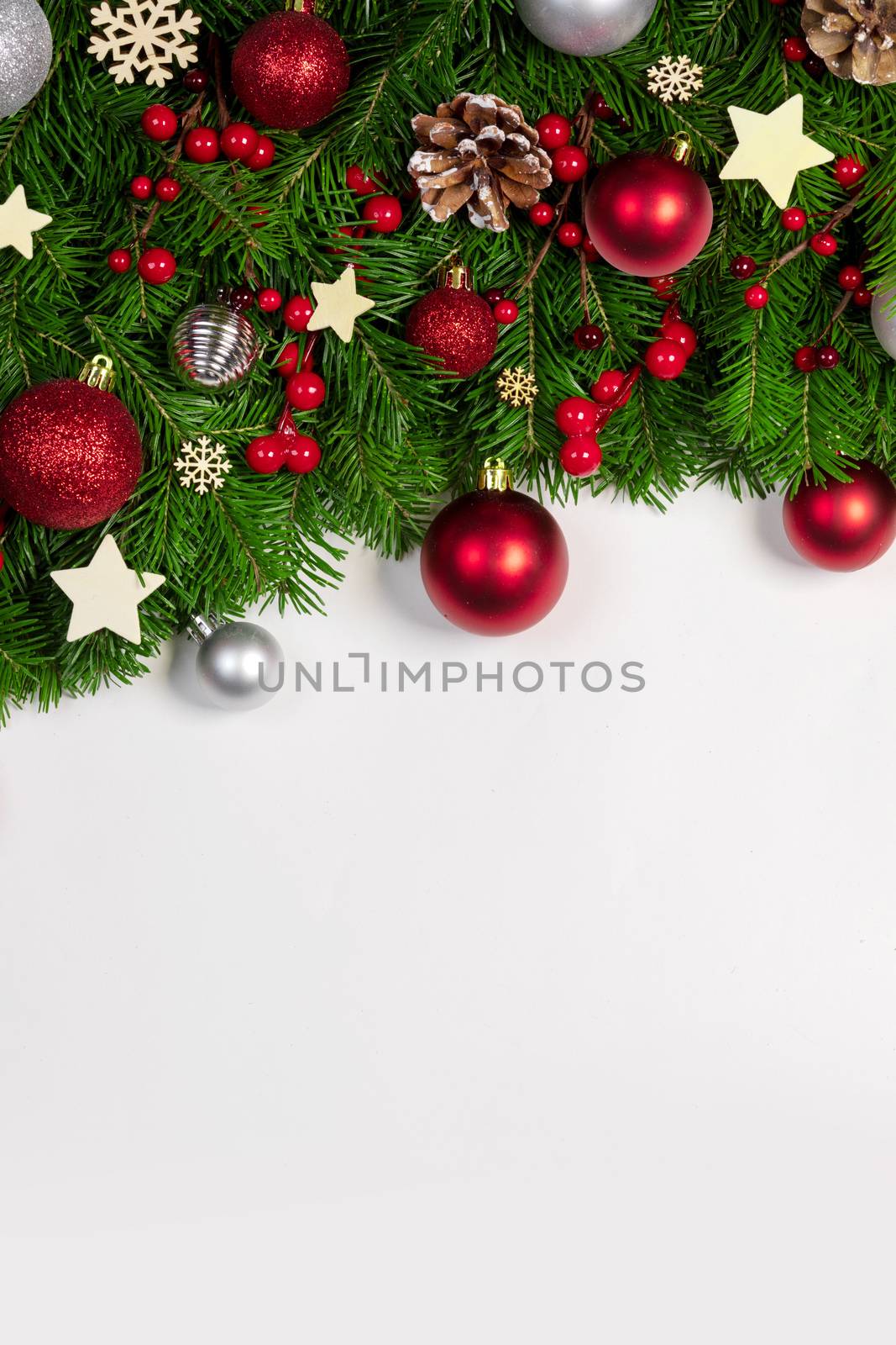 Christmas Border frame of tree branches on white background with copy space isolated, red and golden decor, berries, stars