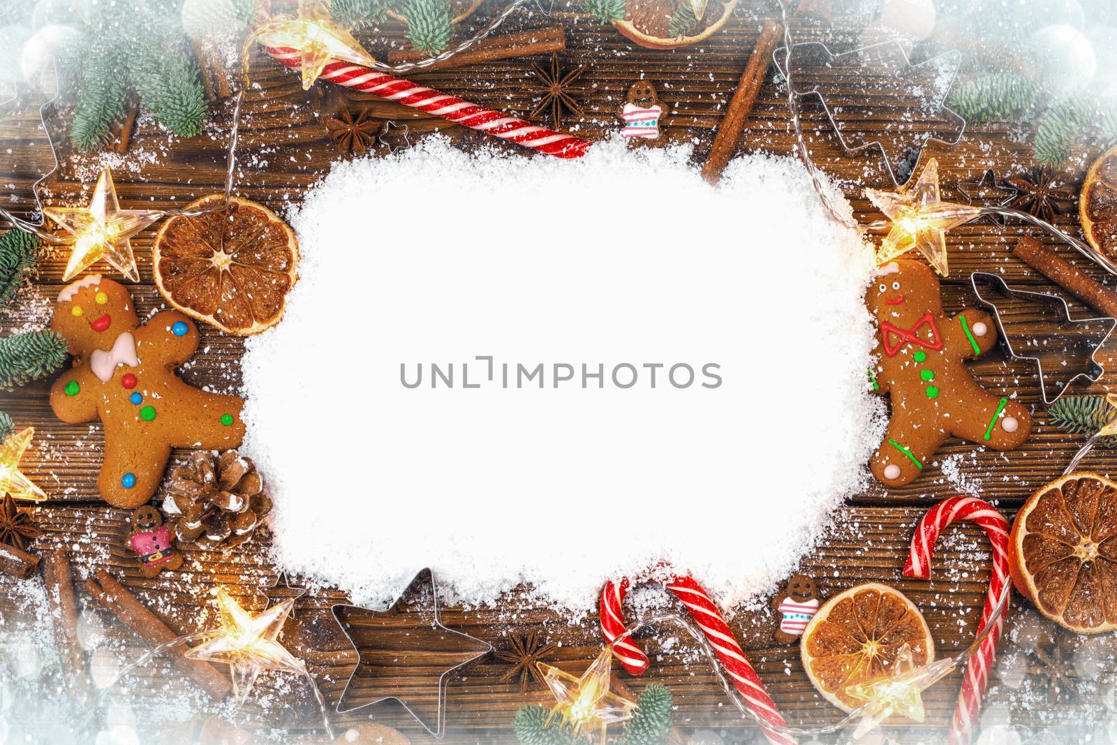 Christmas food frame. Gingerbread cookies, spices and decorations on wooden background with copy space on snow