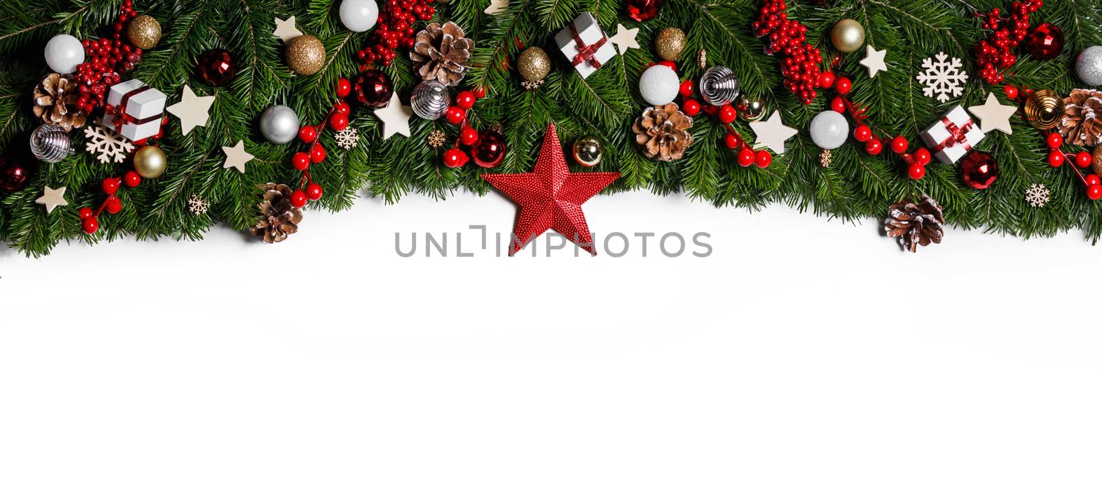 Christmas Border frame of tree branches on white background with copy space isolated, red and golden decor, berries, stars, cones