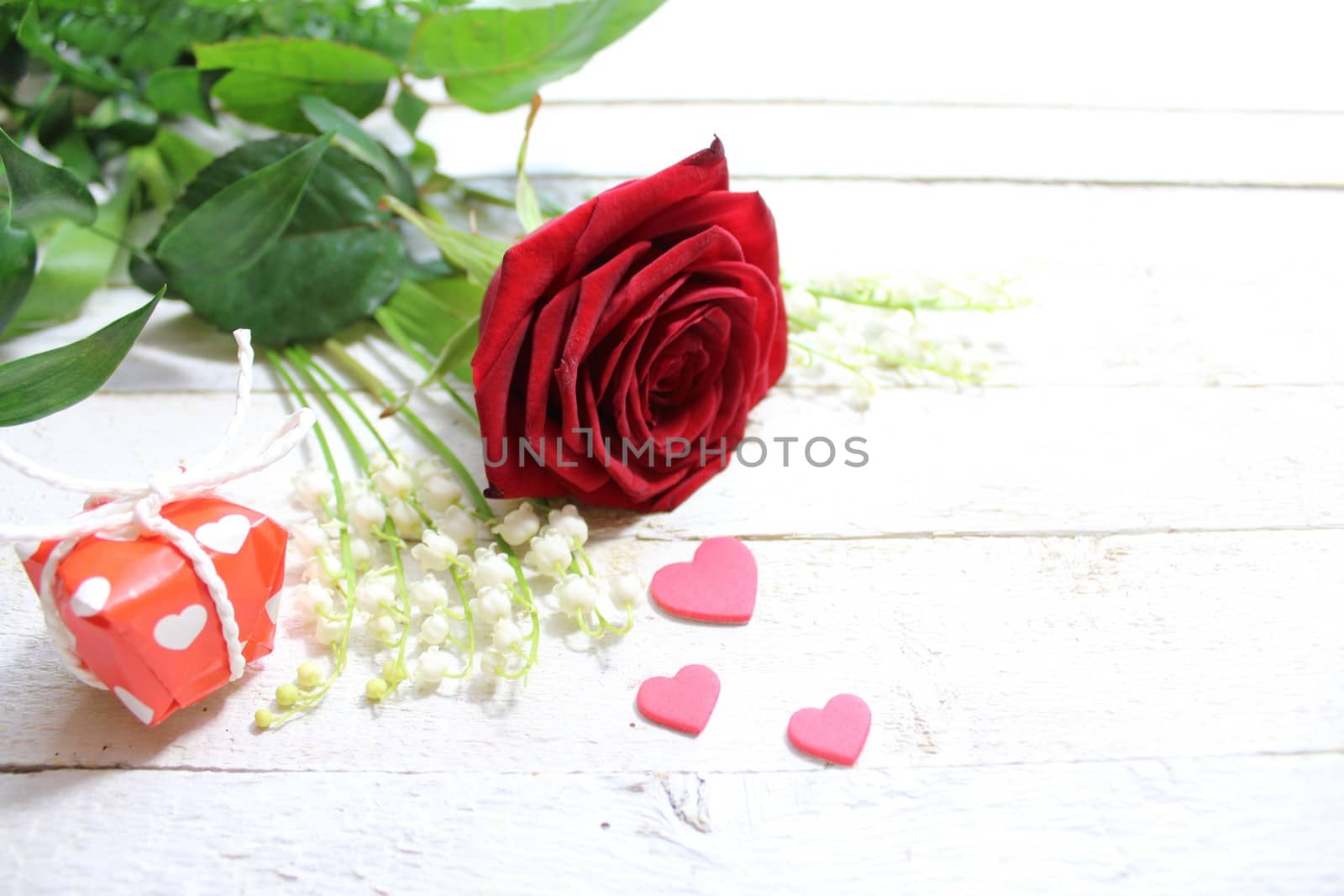 The picture shows flower greetings with hearts and a gift.