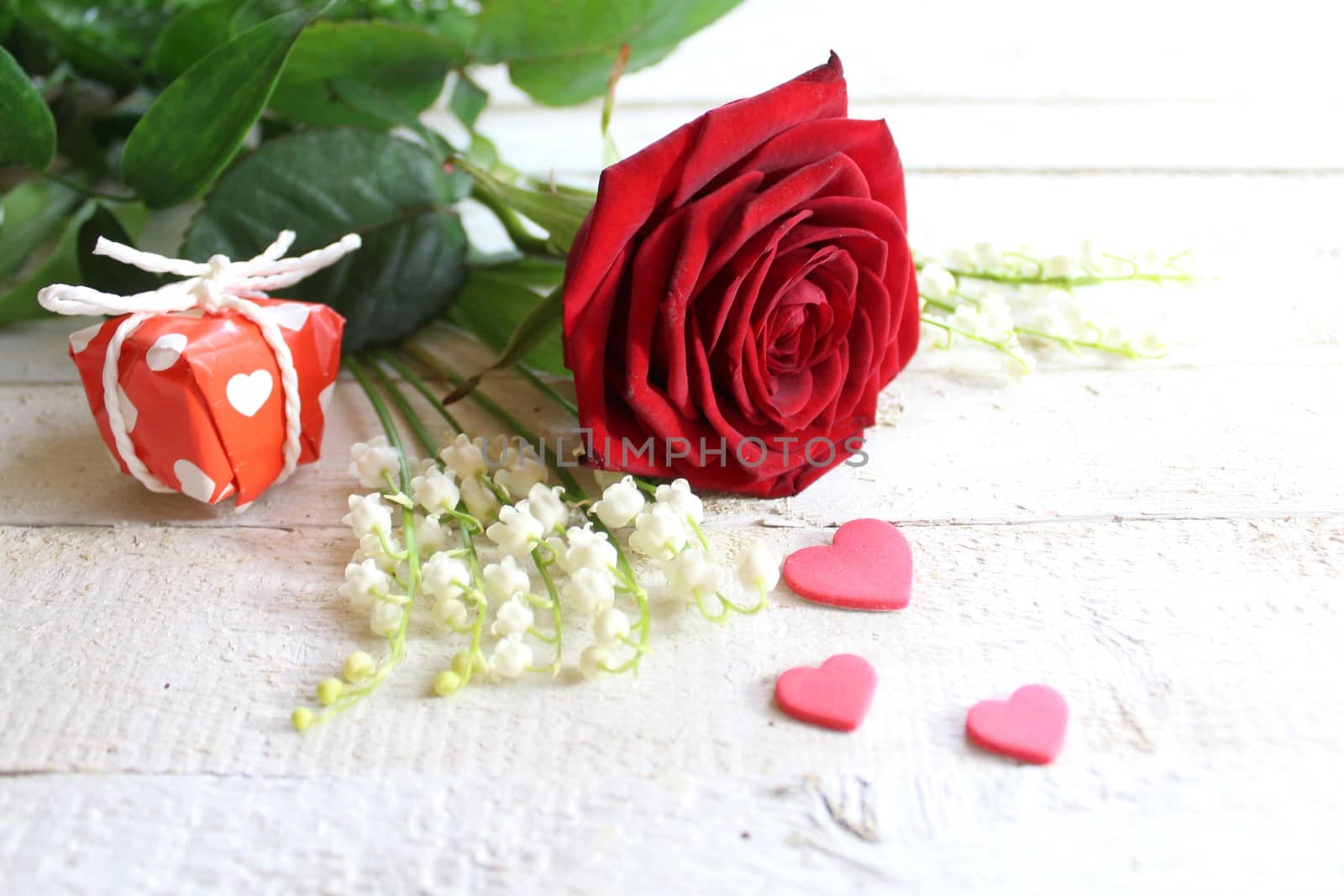 The picture shows flower greetings with hearts and a gift.