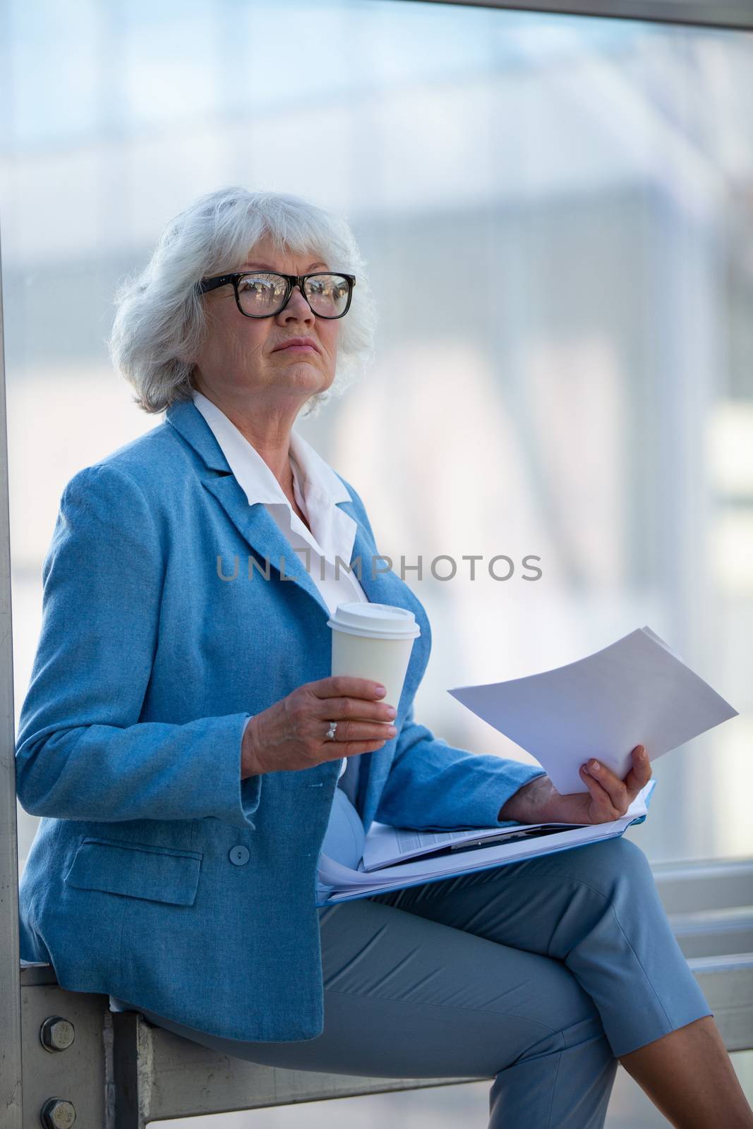 Senior business woman at coffee break with documents