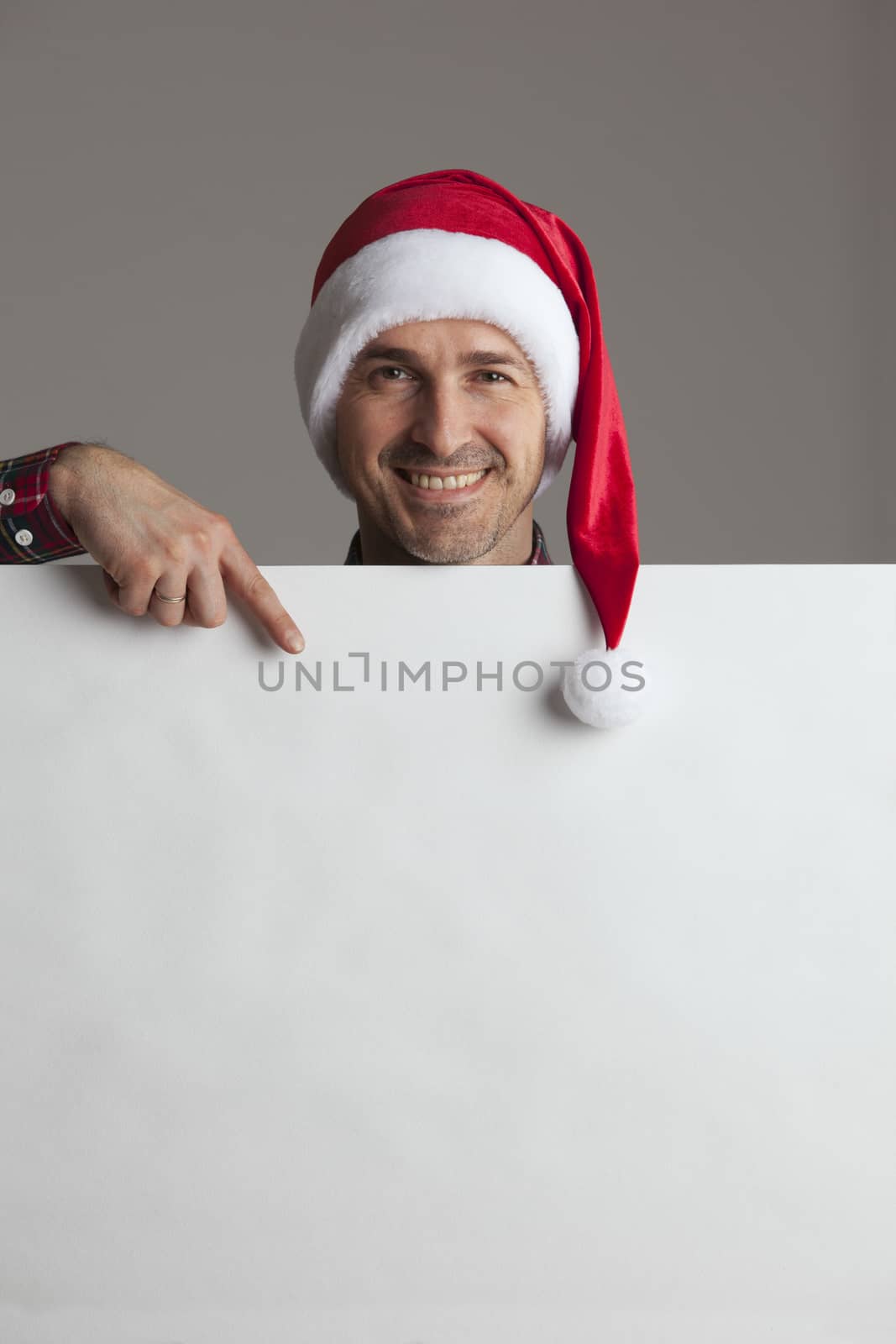 Happy man in Santa hat holding blank banner with copy space