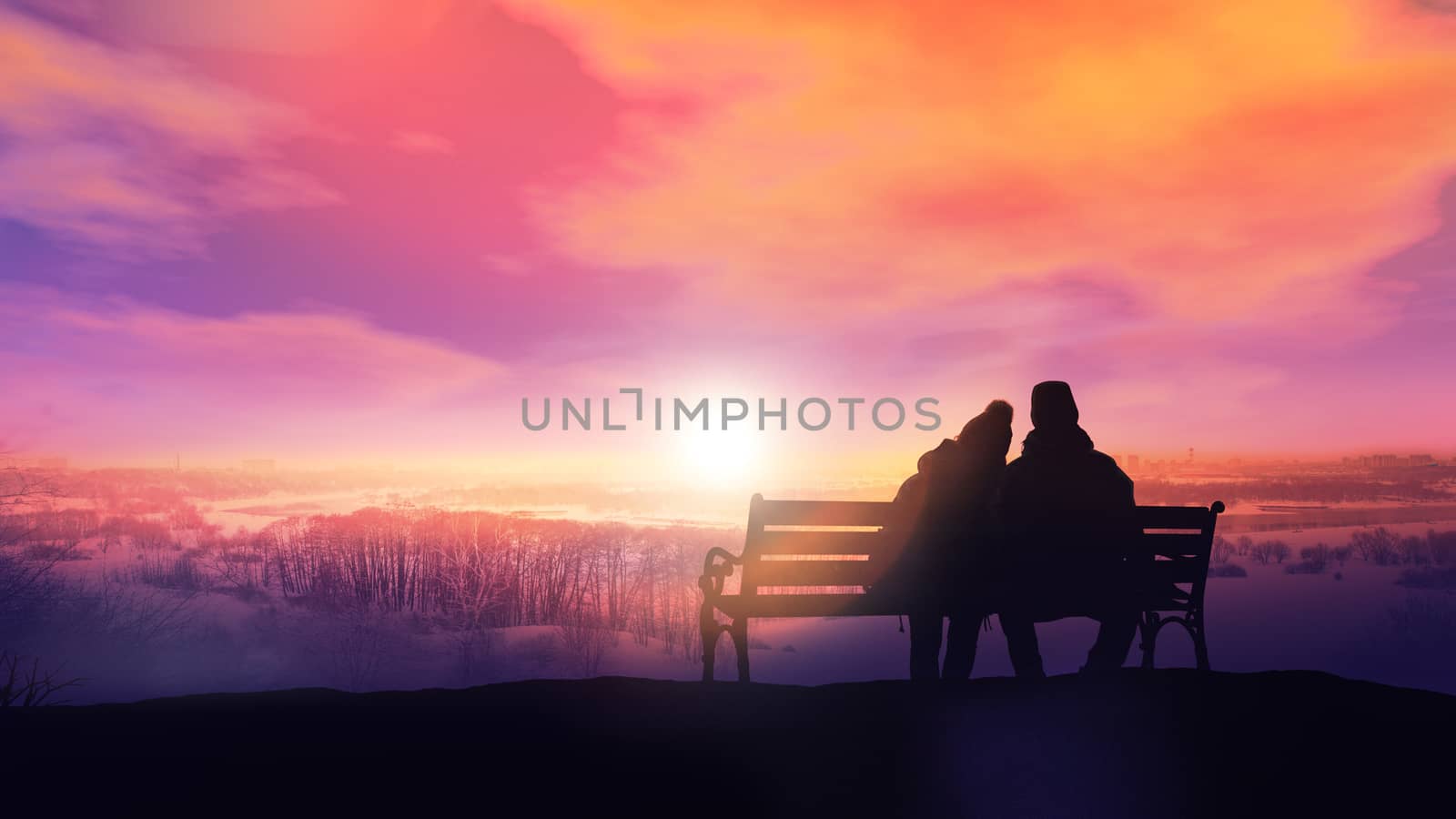 Silhouettes of a couple in love sitting on a bench and watching the winter landscape.