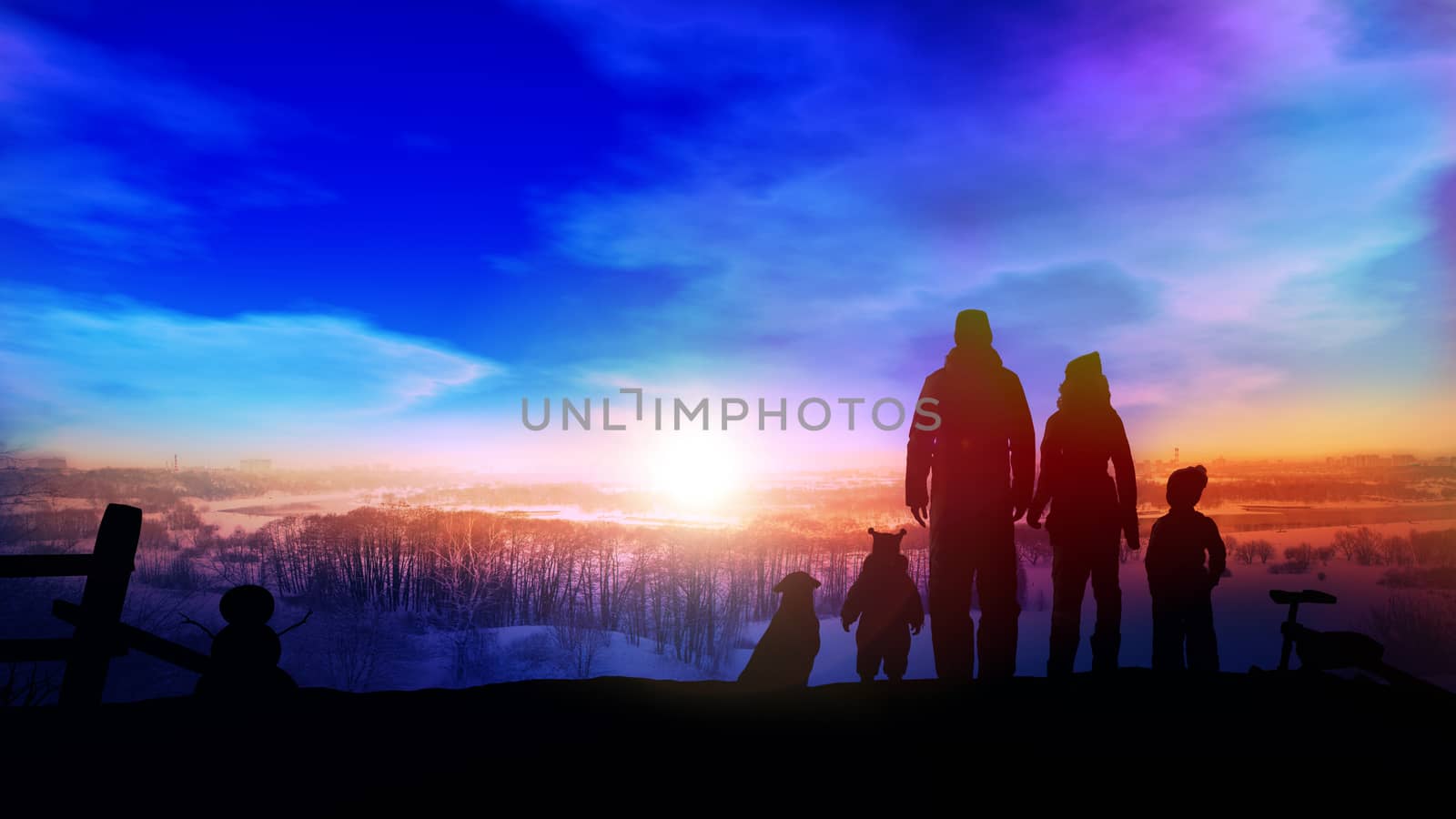 The family's silhouettes stand on a big winter slide opposite the setting sun.