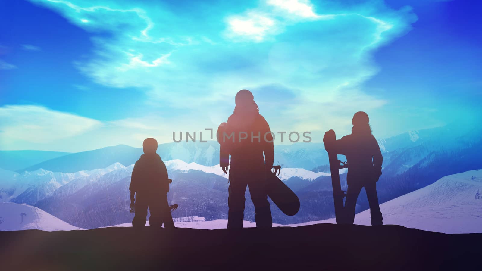 A family of snowboarders looks at the snowy mountains from the top.