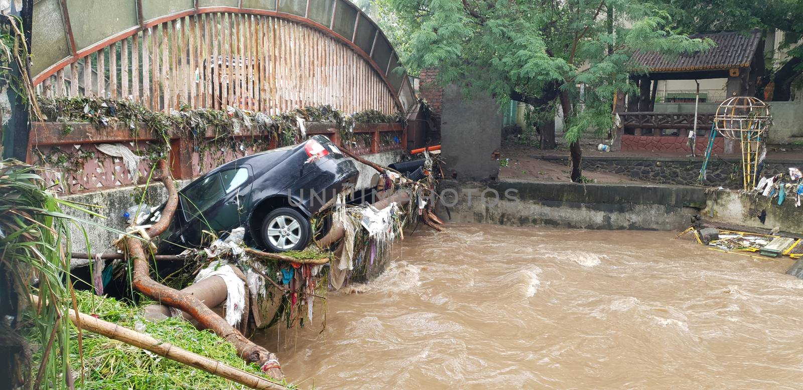 A car which got carried with floods water stuck in a bridge in India.