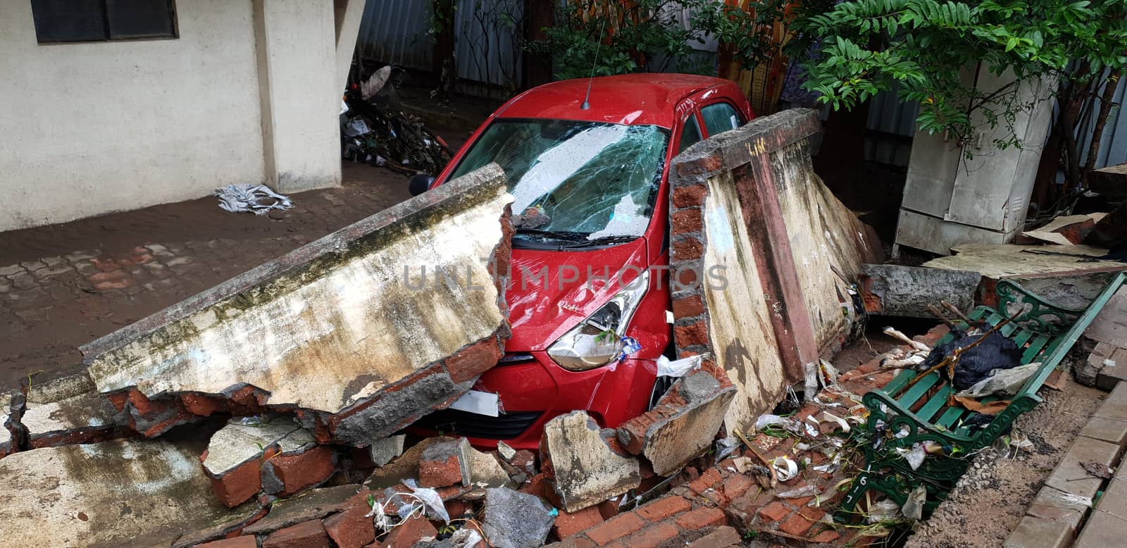 A car destroyed by a wall during floods in India, during the monsoons.