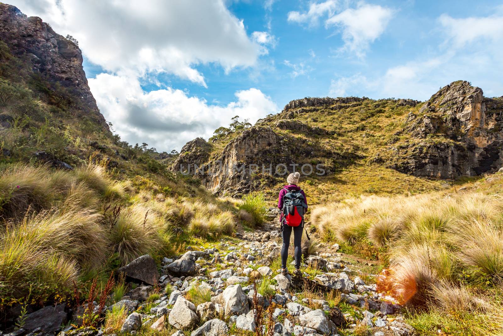 Hiker in Snowy Mountains walking through a dry gorge by lovleah