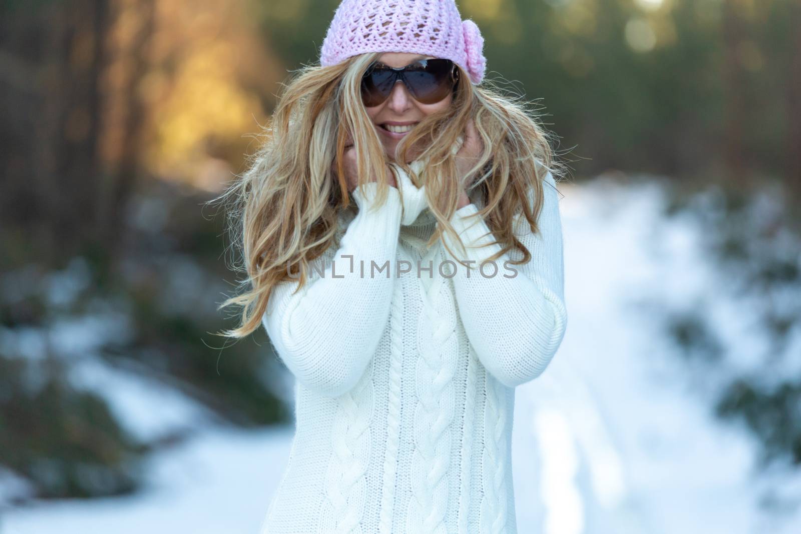 Happy adult woman wearing big woolly sweater in snow by lovleah