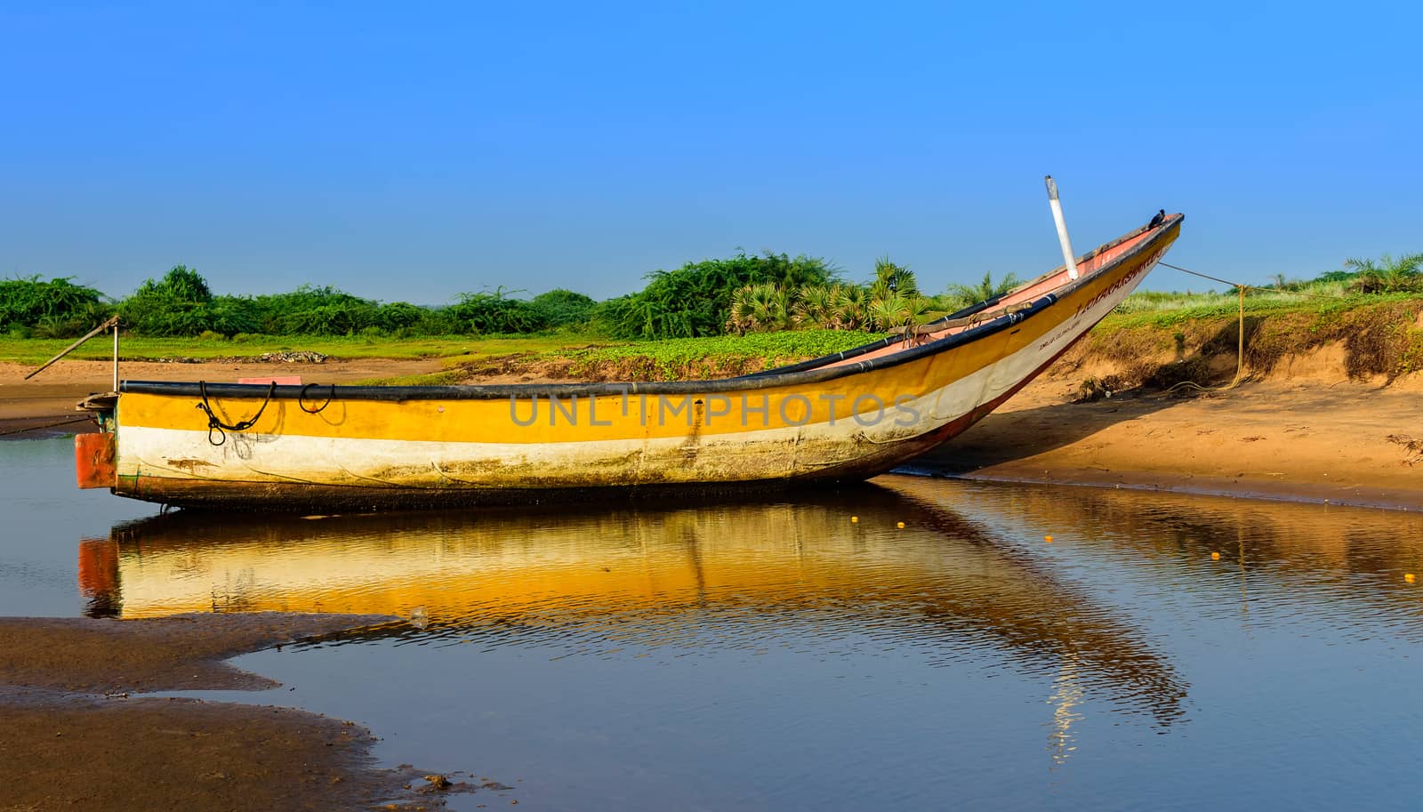 Local colorful fishing boat anchored in the shallow water, copy space