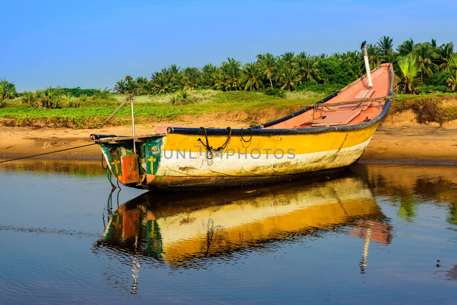 Local colorful fishing boat anchored in the shallow water, copy space