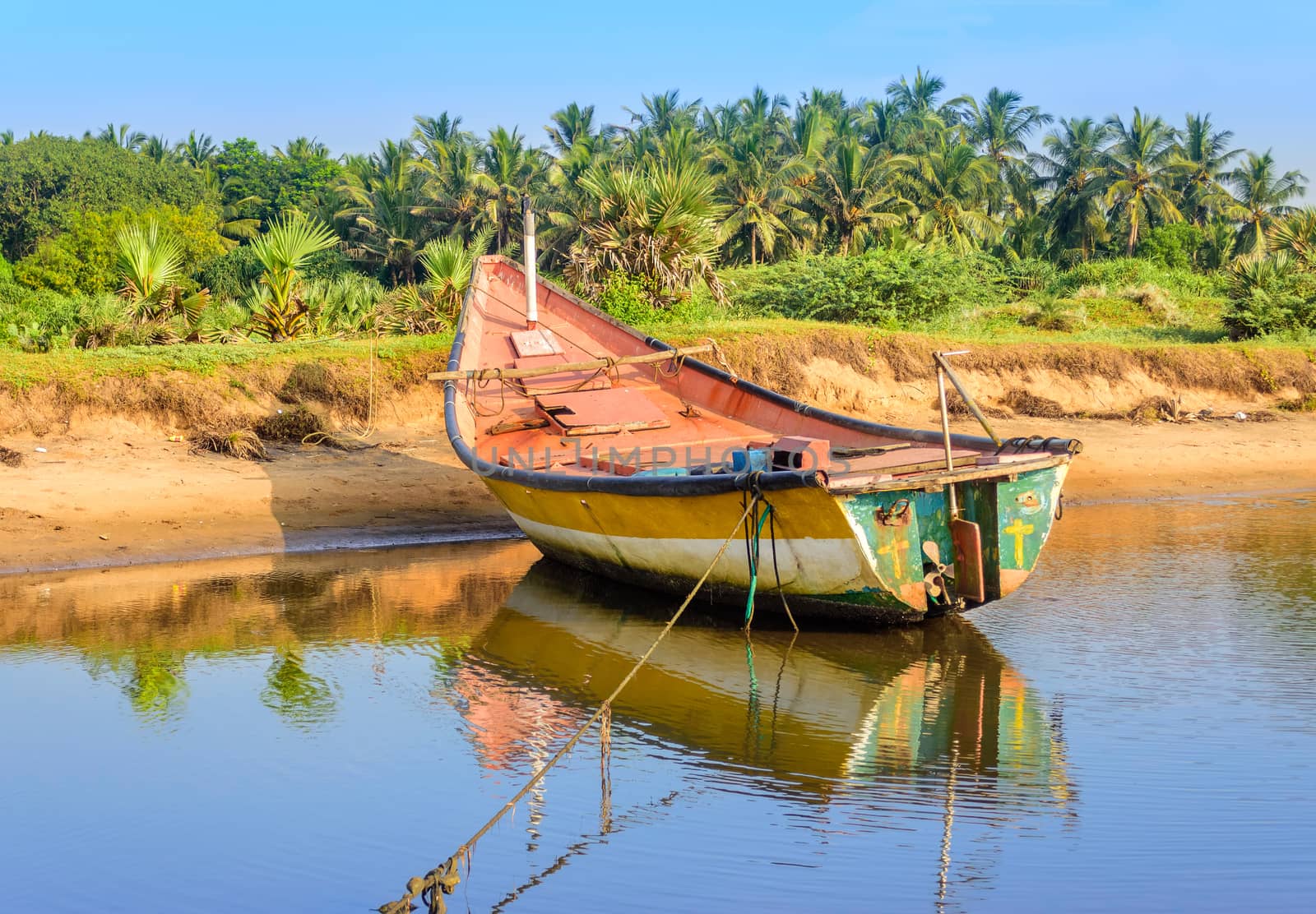 Local colorful fishing boat anchored in the shallow water, copy space