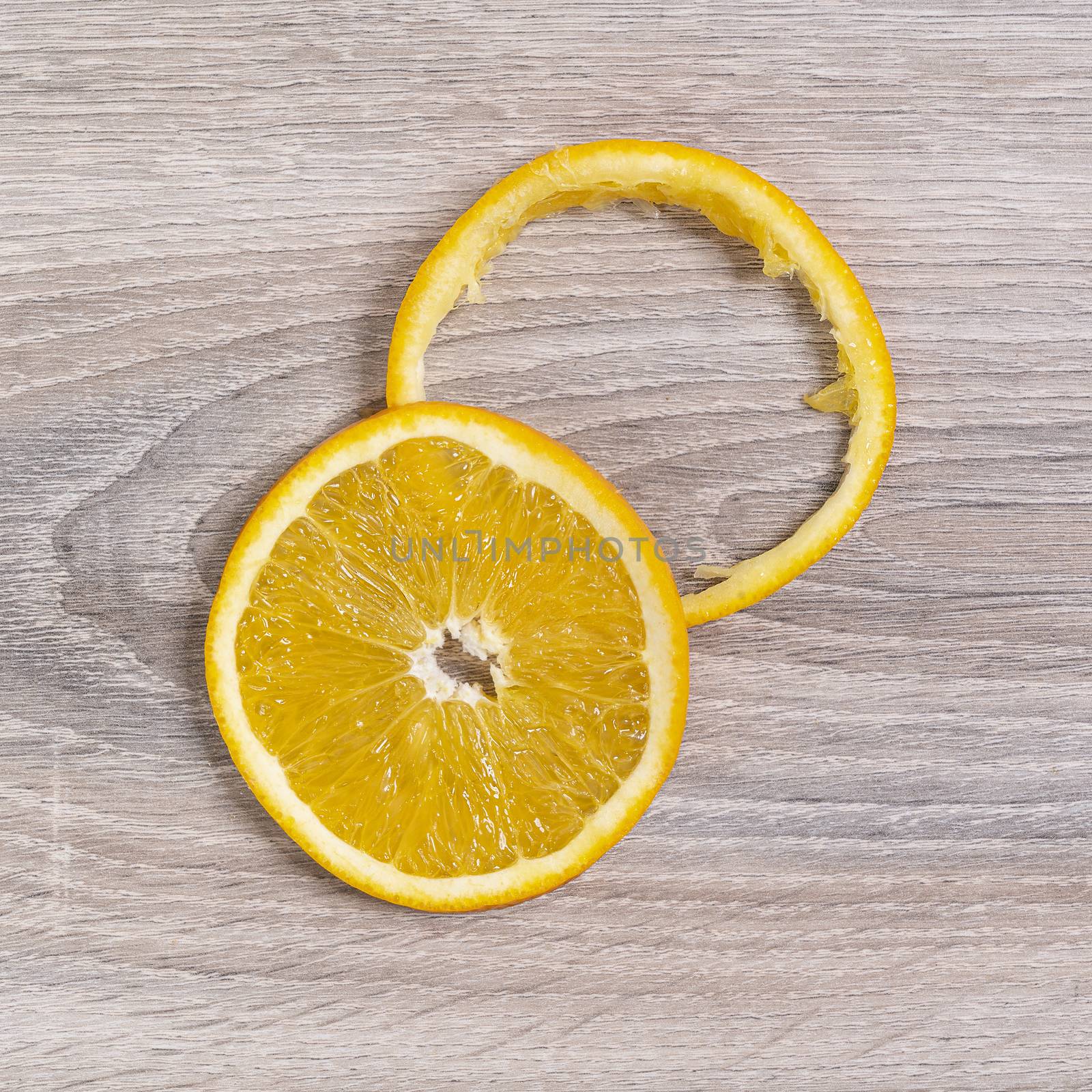 on a slice and an orange peel on a wooden table