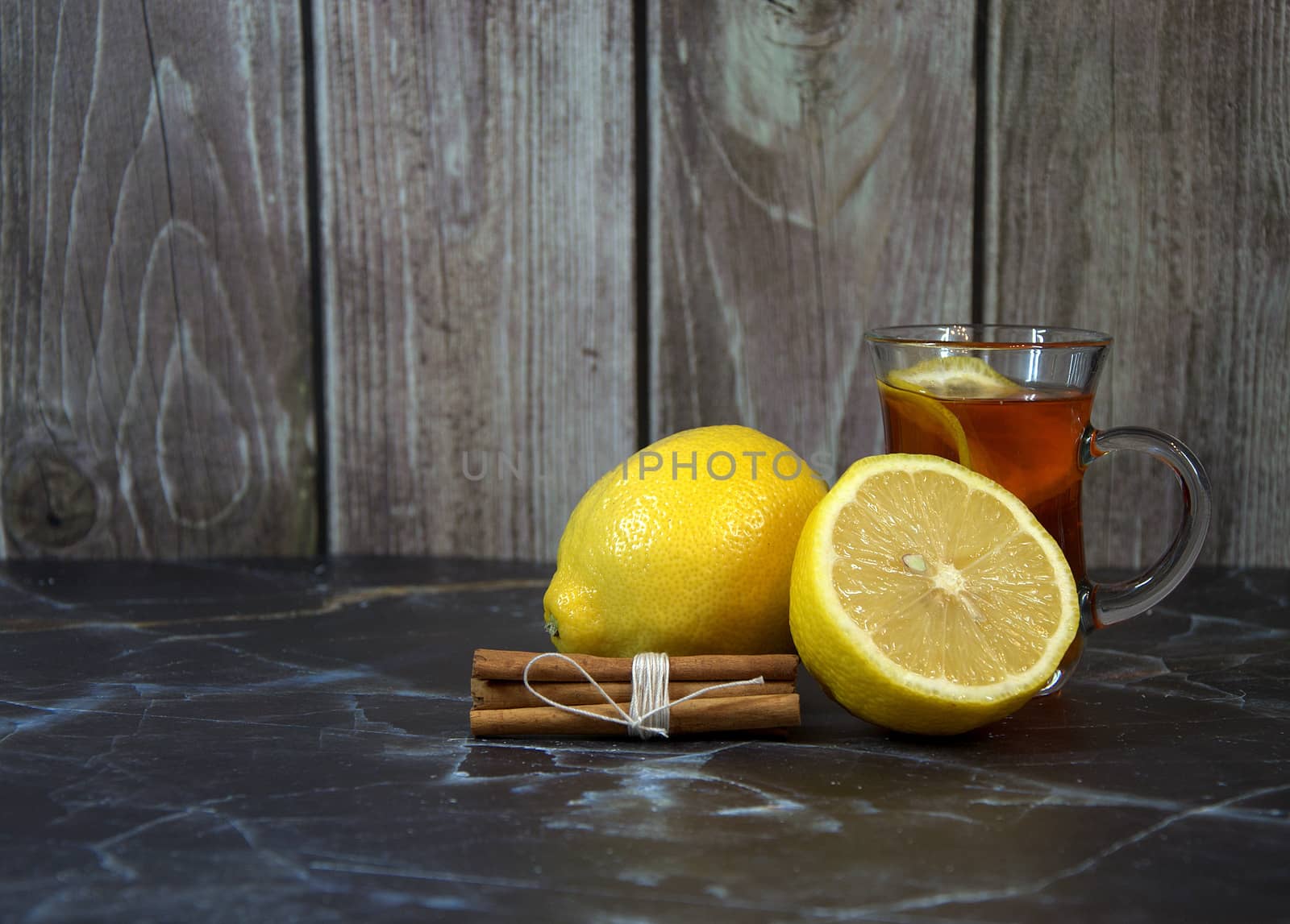 The best cold medicine, hot lemon tea and cinnamon sticks. Close-up.