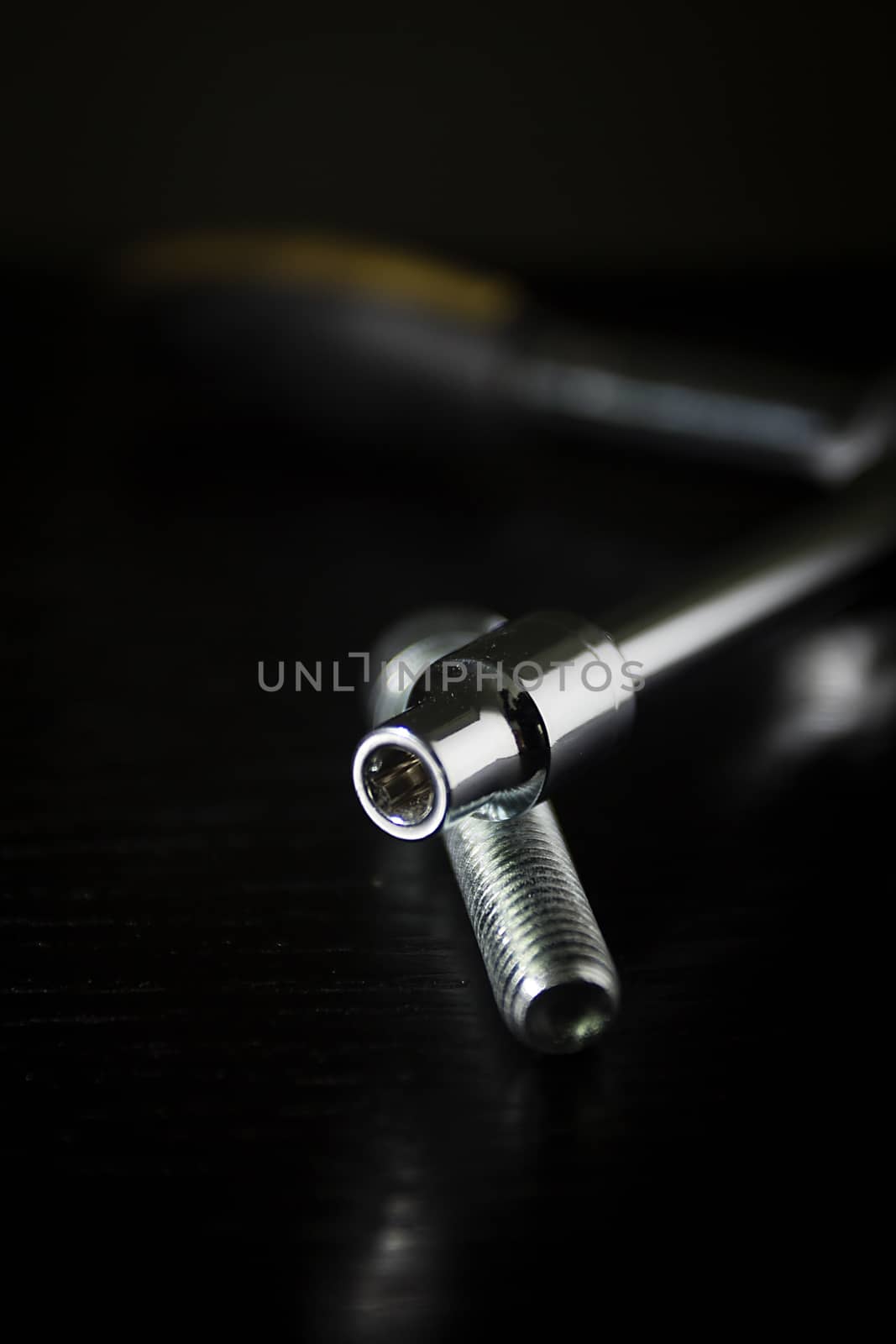 Ring wrench and bolt on a black background