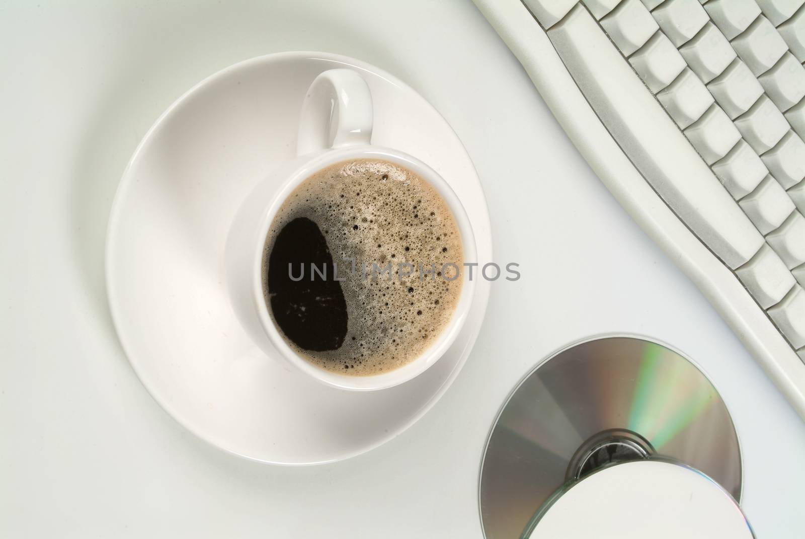 Cup of coffee, DCs and keyboard on a studio background