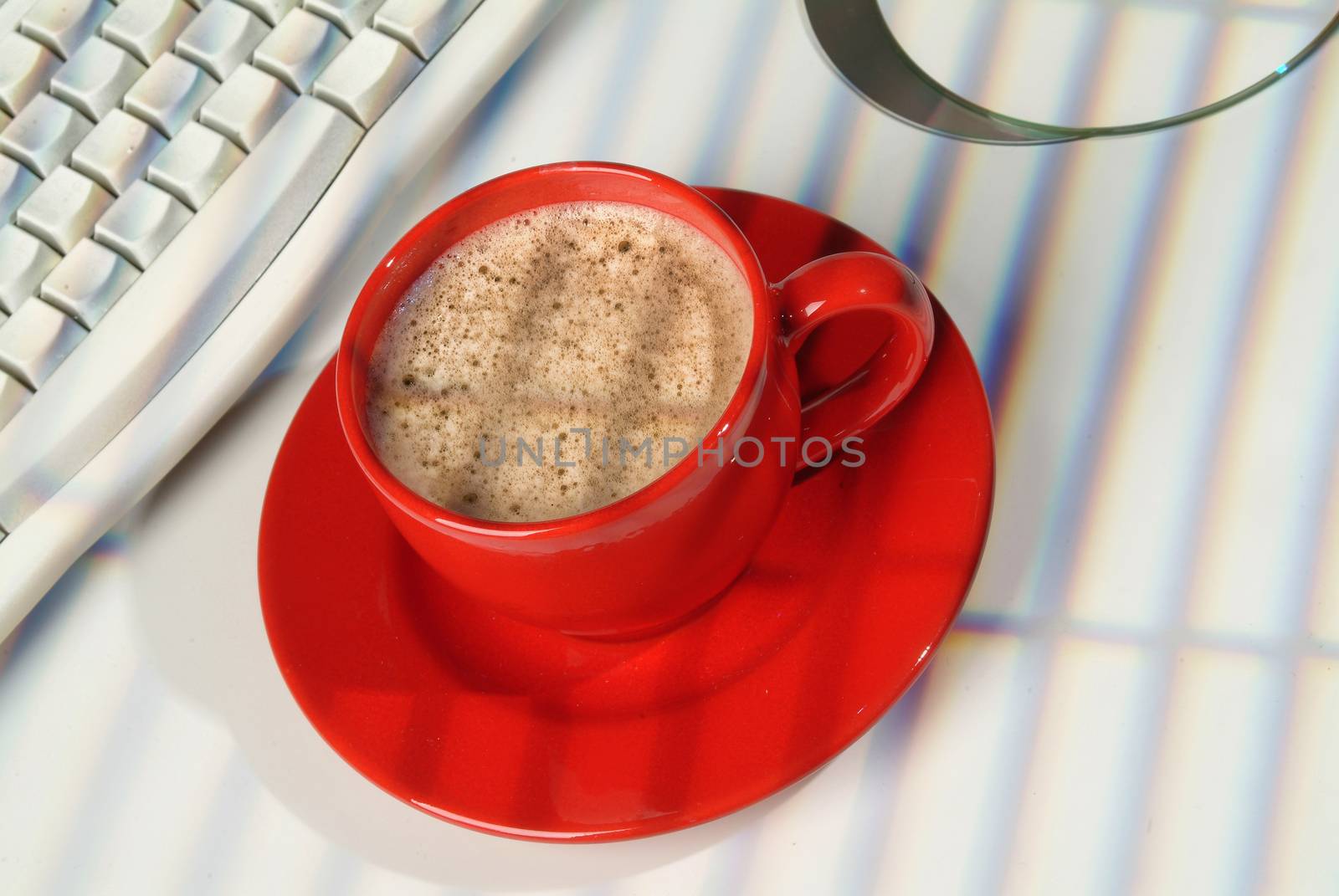 Cup of coffee, DCs and keyboard on a studio background
