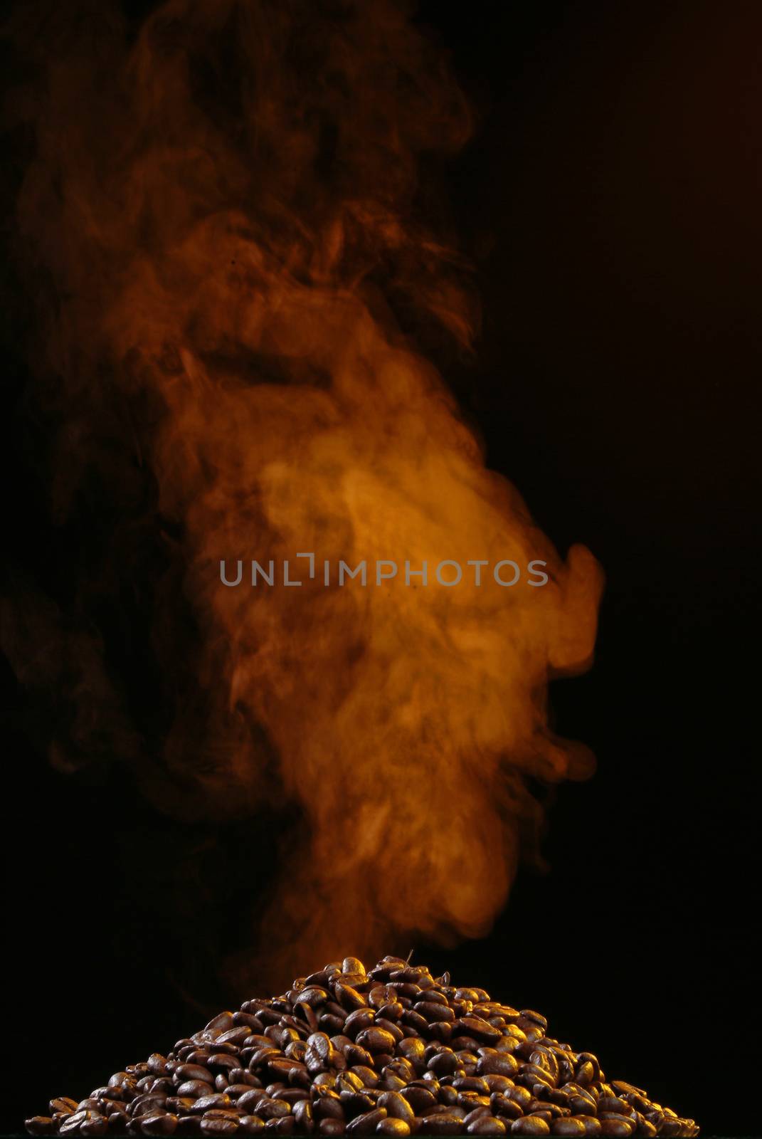 Coffee beans and smoke on a black studio background
