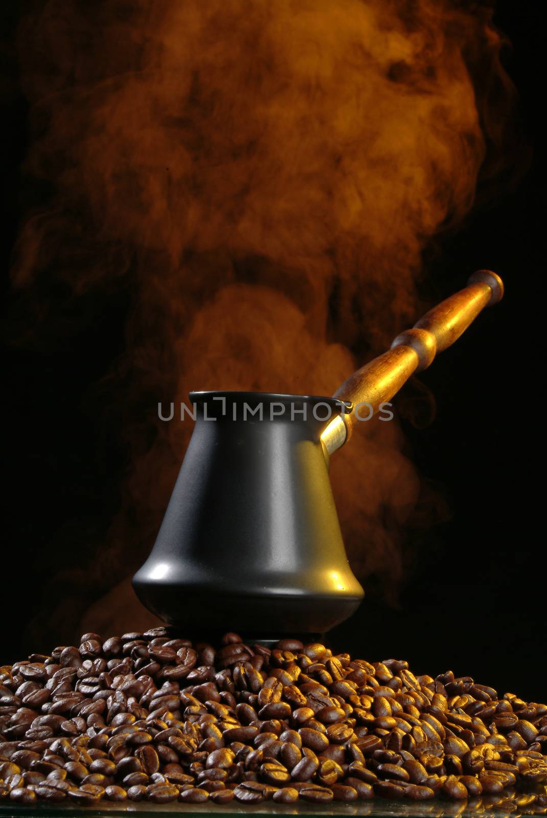 Coffee beans and smoke on a black studio background