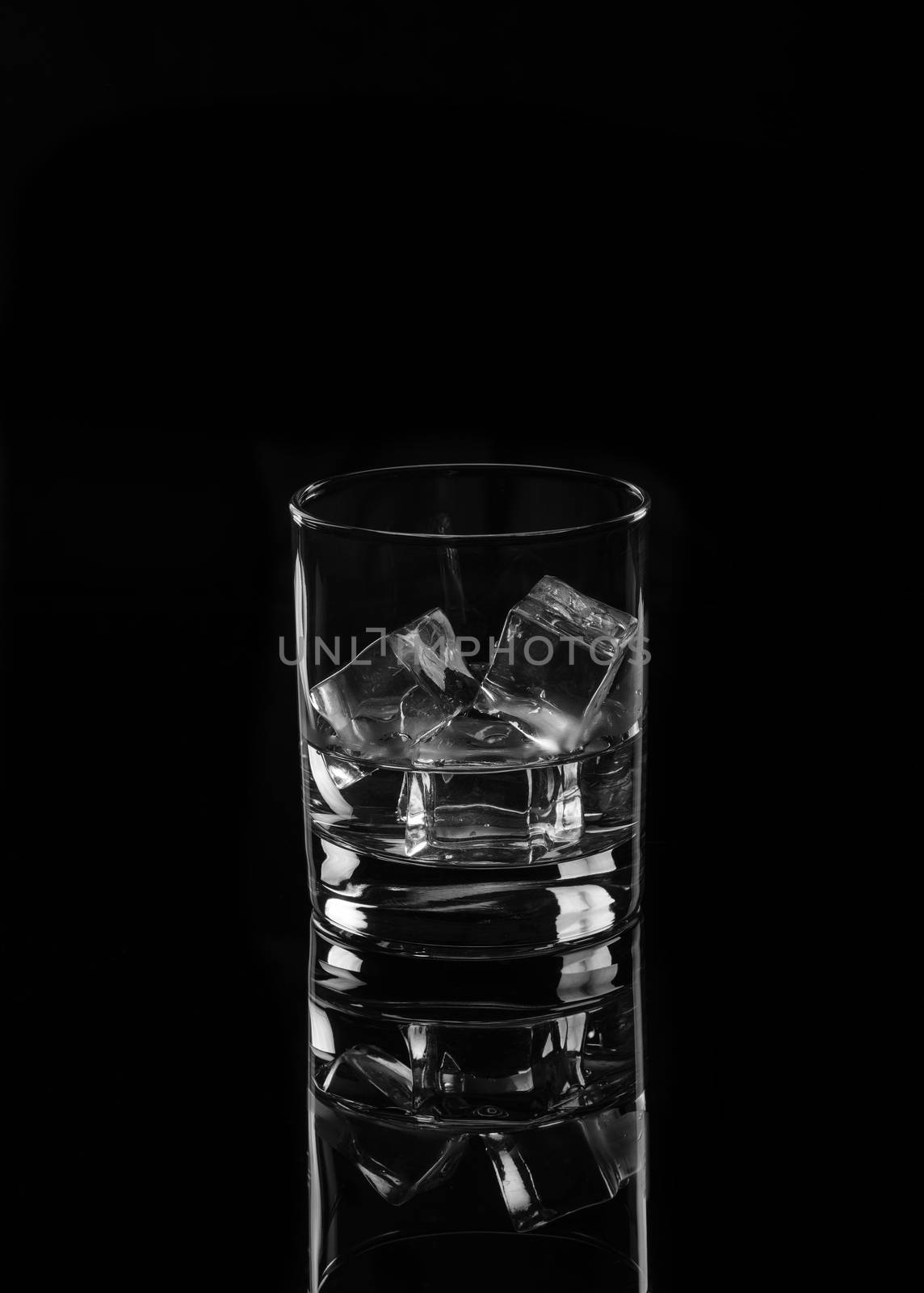 Vodka or gin tonic with ice in rocks glass on black background including clipping path
