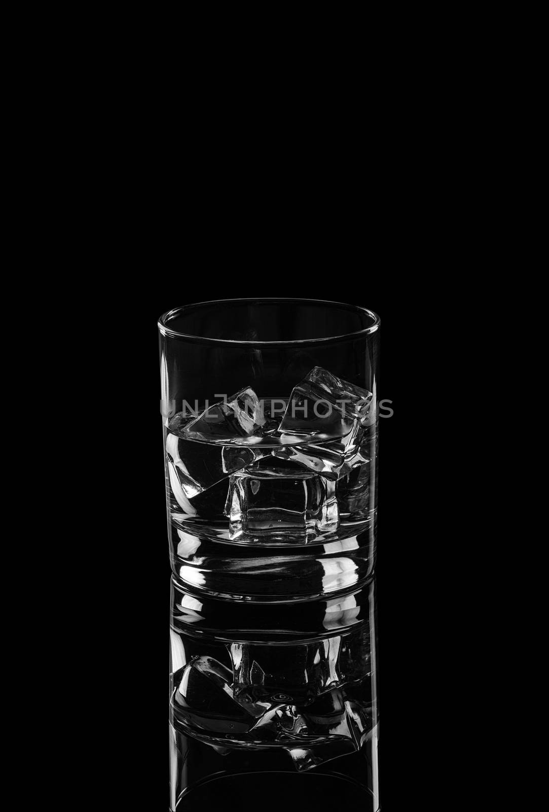 Vodka or gin tonic with ice in rocks glass on black background by dmitry_derenyuk