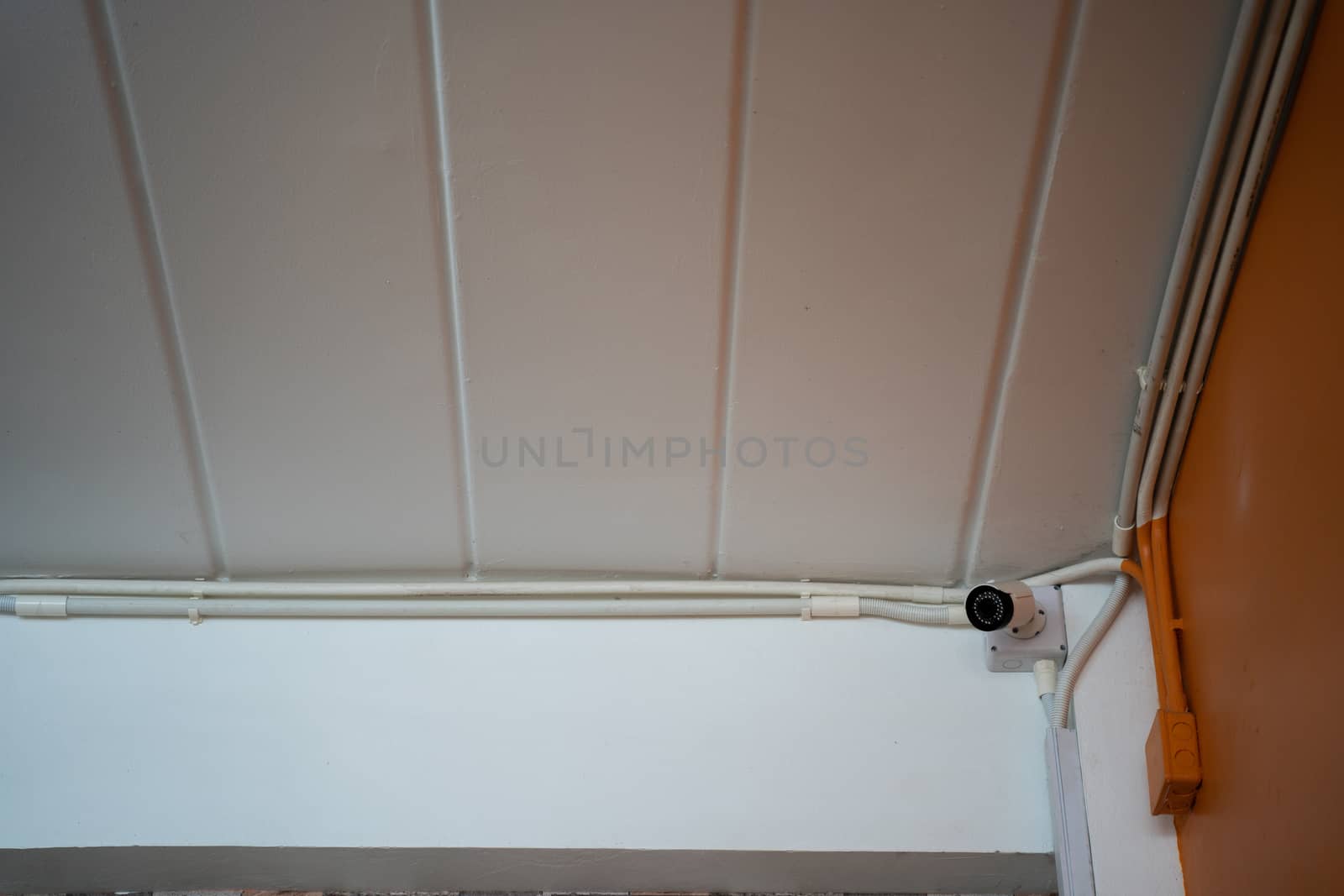 A CCTV security camera installed on ceiling building