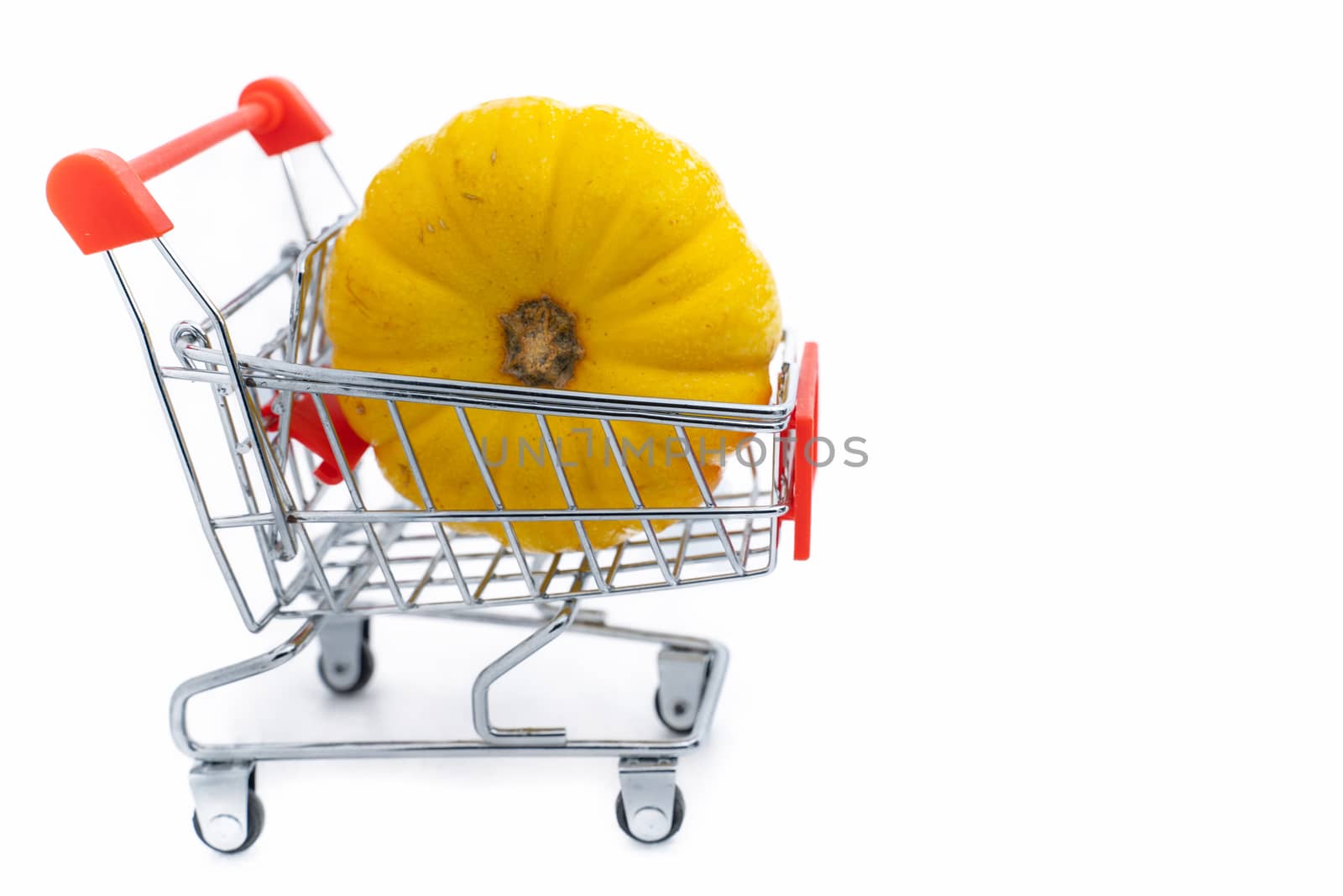 A Fresh orange pumpkin in shopping cart on isolated white background