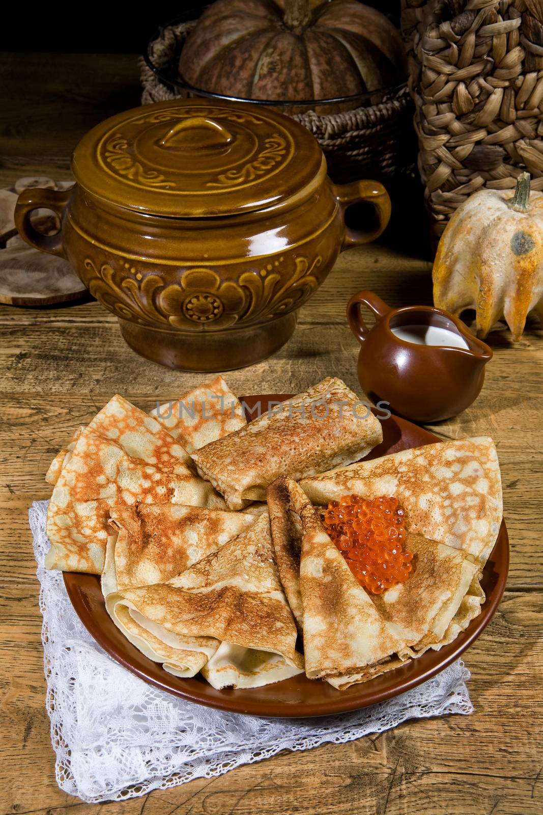 Pancakes with red caviar ona desk